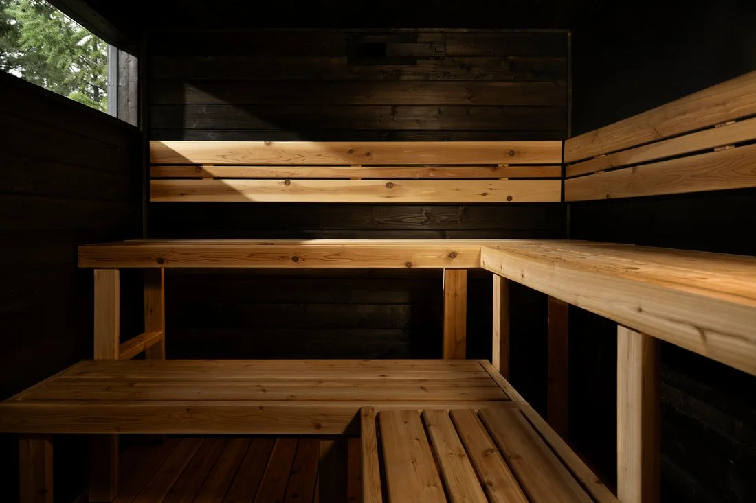 Pihka sauna interior with cedar benches and dark walls