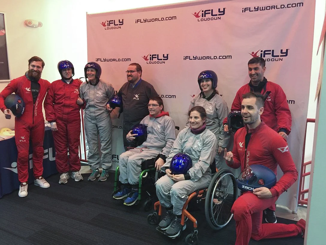 A group photo of members and volunteers after indoor skydiving at iFly