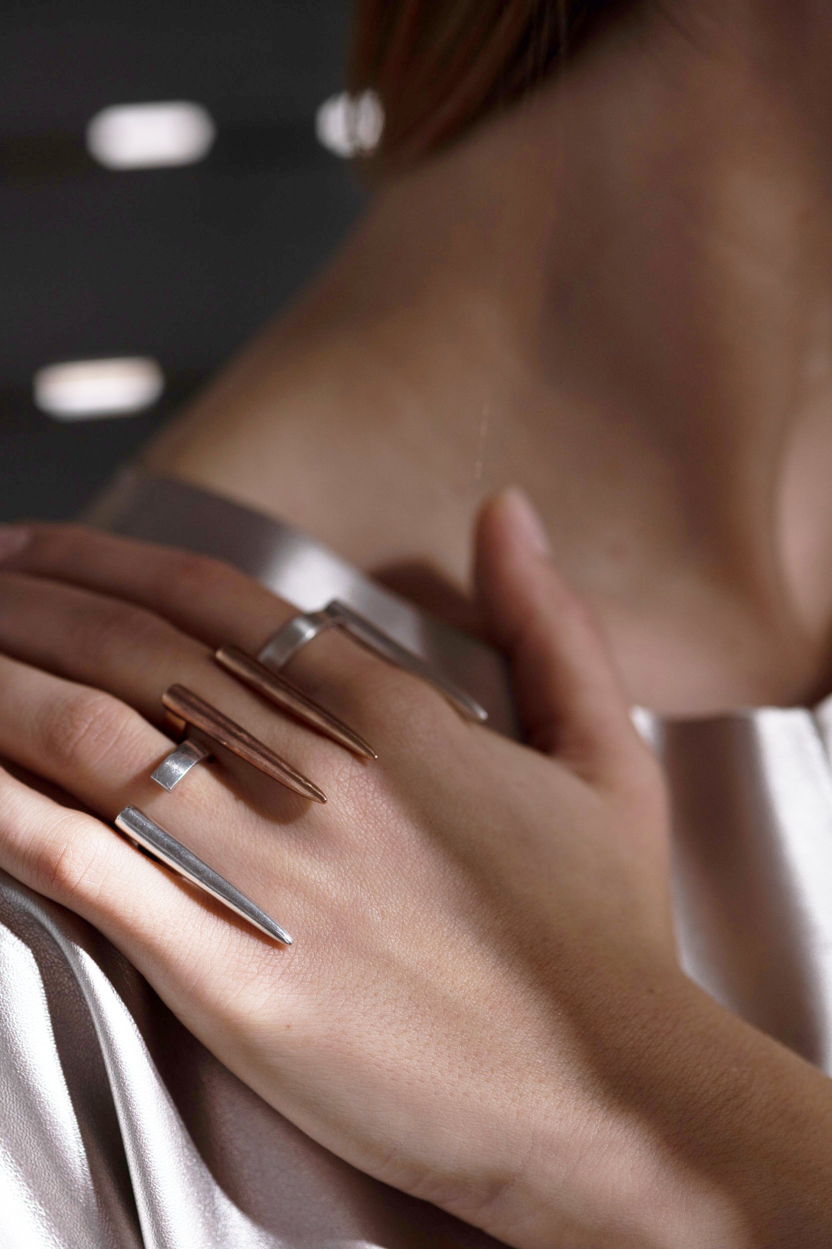 Model wears Temo ring in 18ct rose gold plated sterling silver and Temaz ring in sterling silver - NOMERA Jewellery