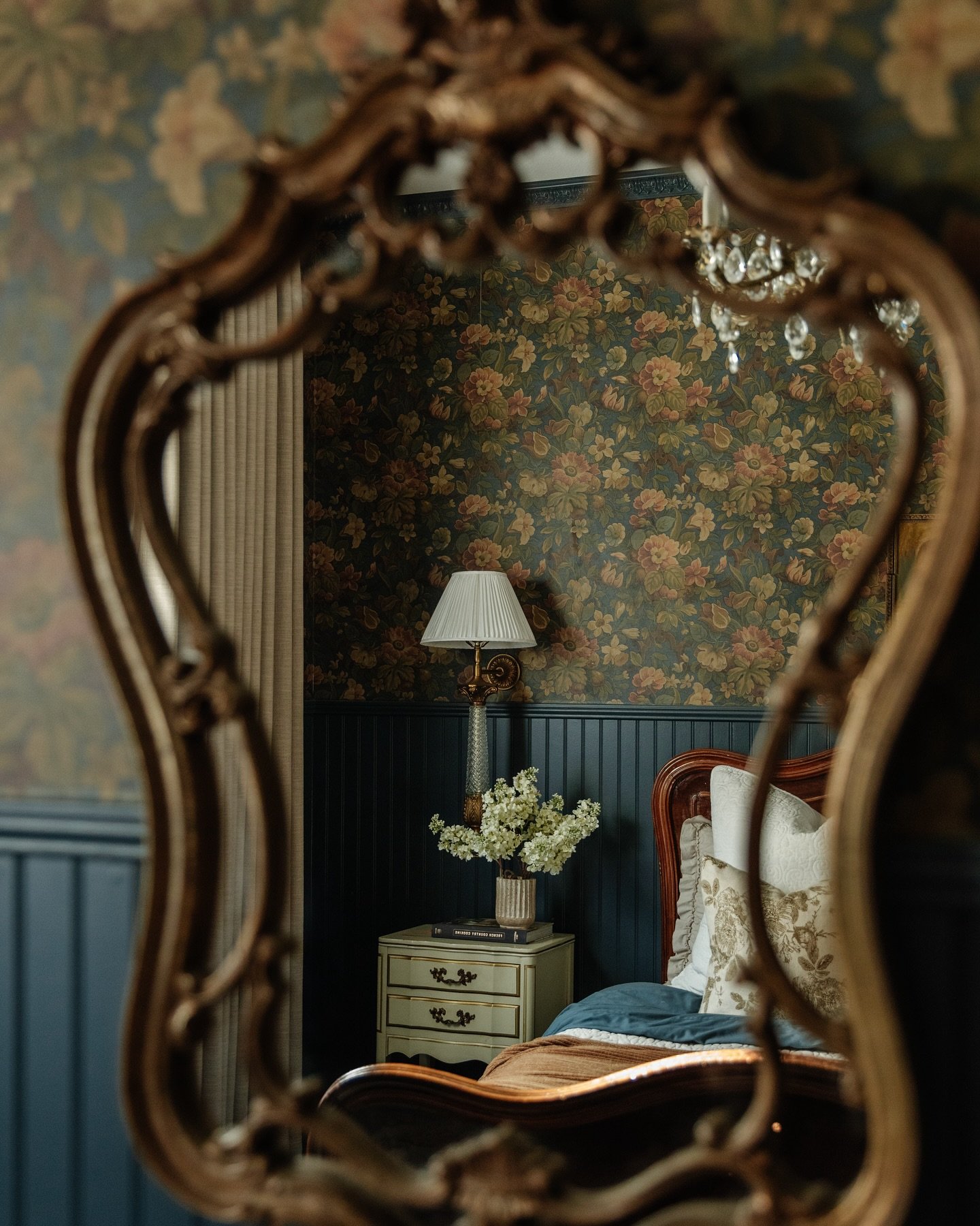 Proof that traditional doesn&rsquo;t have to mean dated.

This reflection captures a perfectly curated moment&mdash;rich wallpaper, warm wood tones, and layered textures that feel timeless, not tired. A sweet little vignette that makes a big impact. 