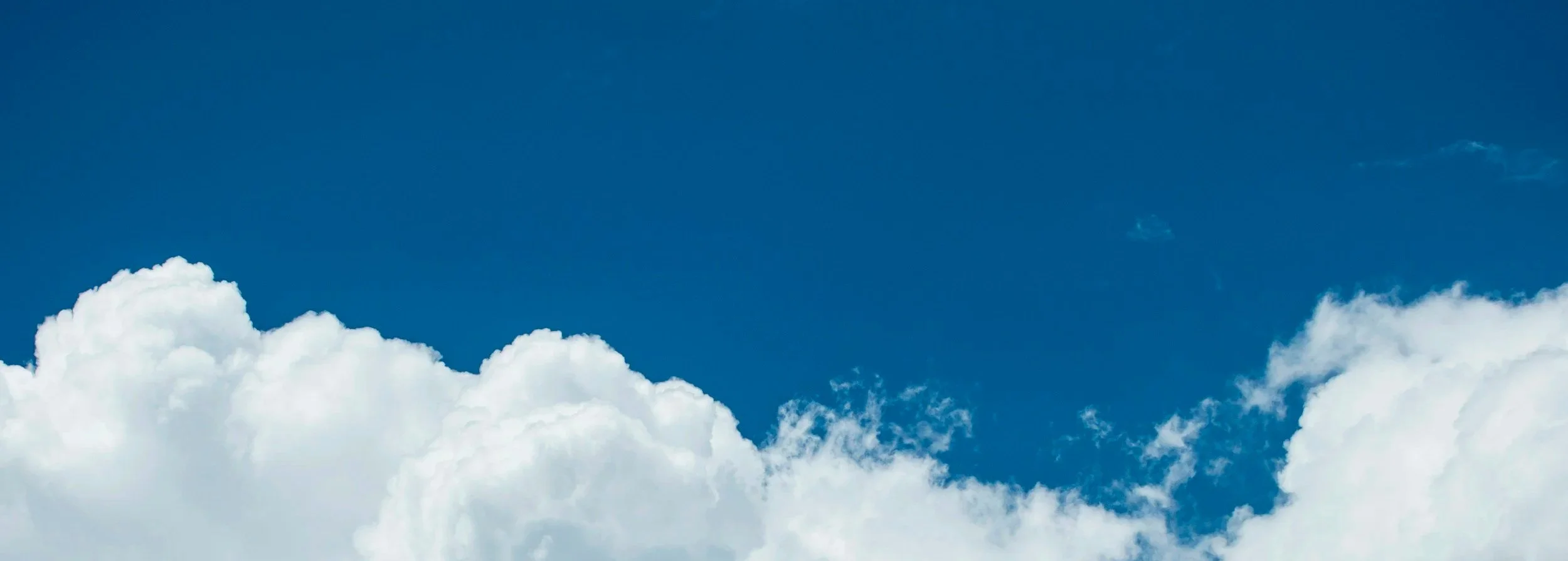 Blue sky and white clouds background for the section introducing exclusive destination retreats designed for law firm founders and managing partners.