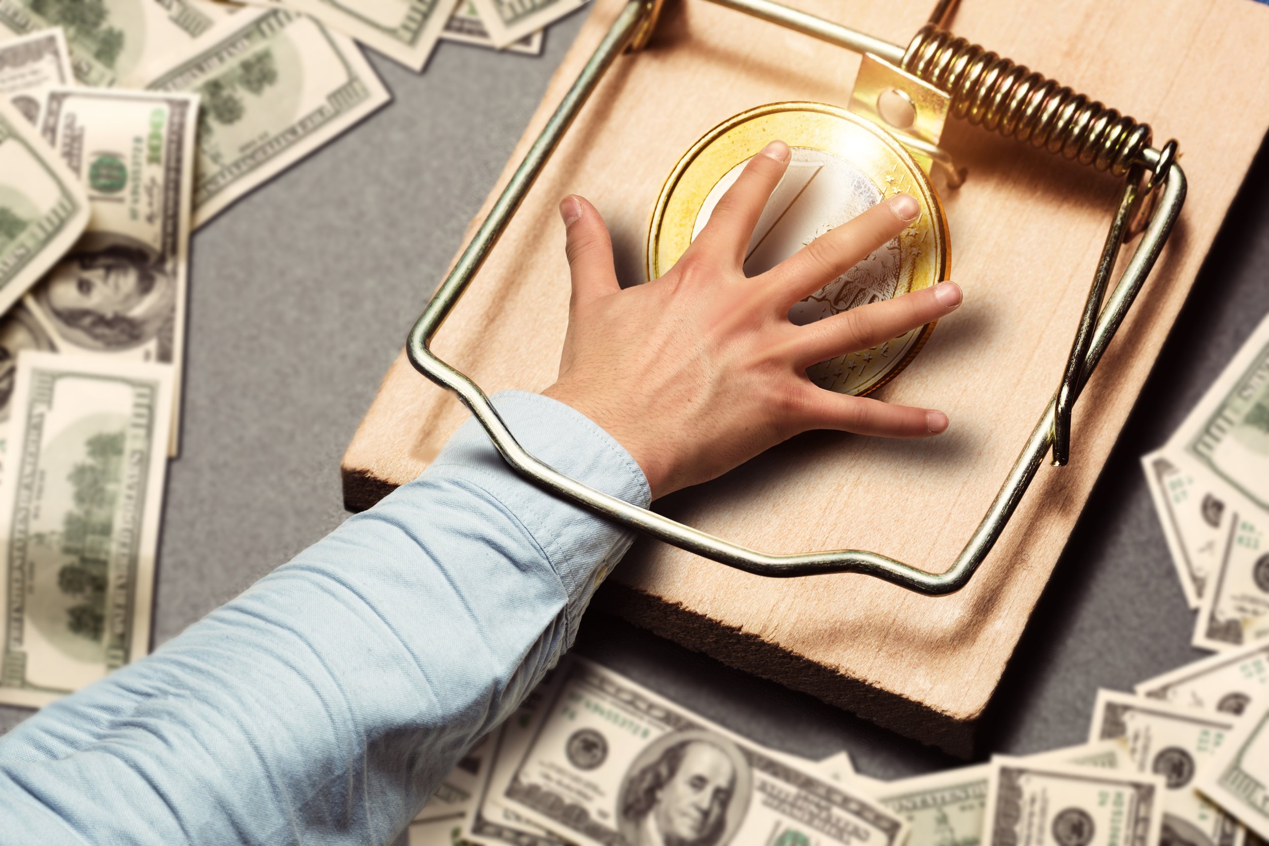 A businessman hand caught in a trap with money