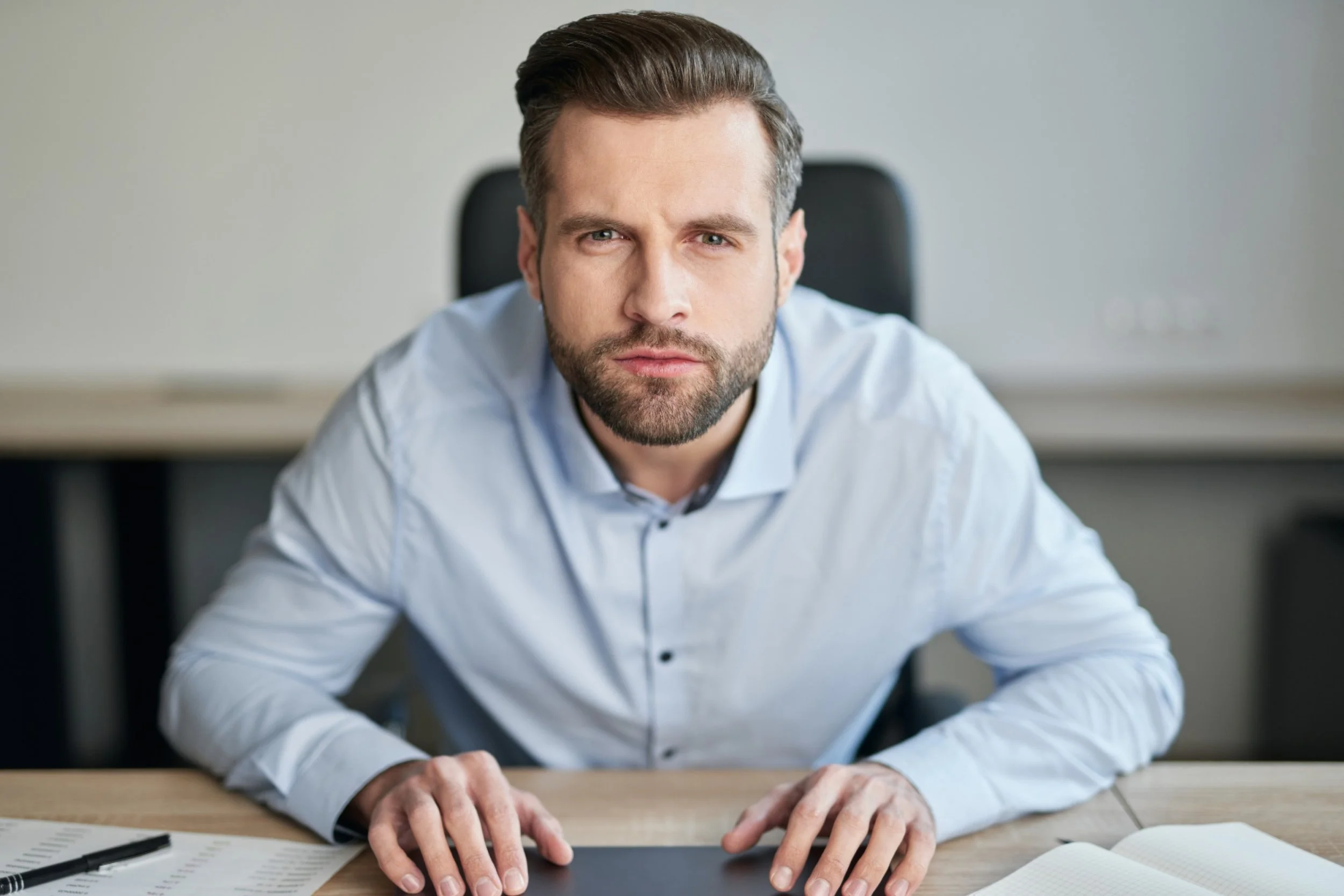 a business man leaning forward at his desk