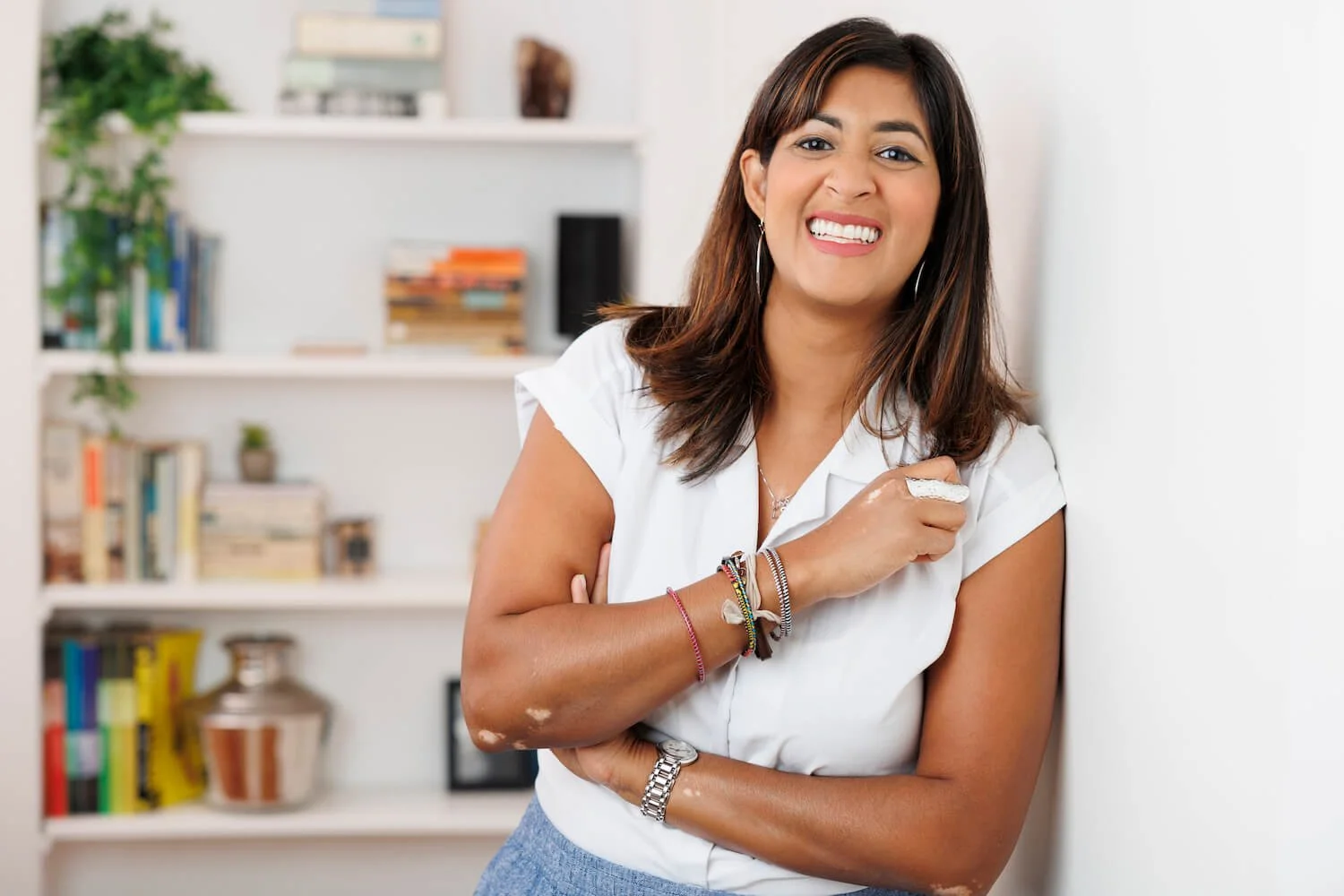 therapist coach Dr. Sumi smiling in office with books in background