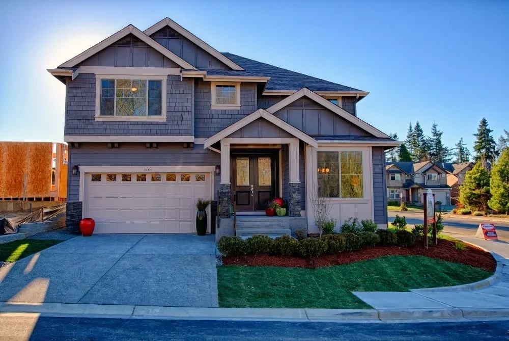 New house next to custom home build in progress.