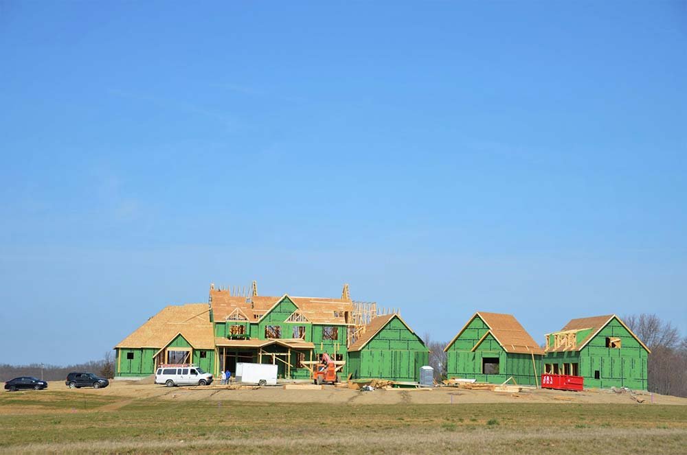 A new custom home under construction, showing the wood framing and sheathing.