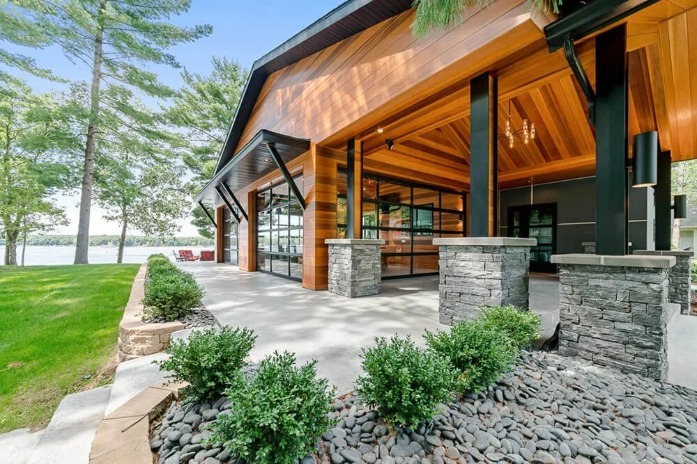 Exterior of custom lake home featuring wood and stone construction.