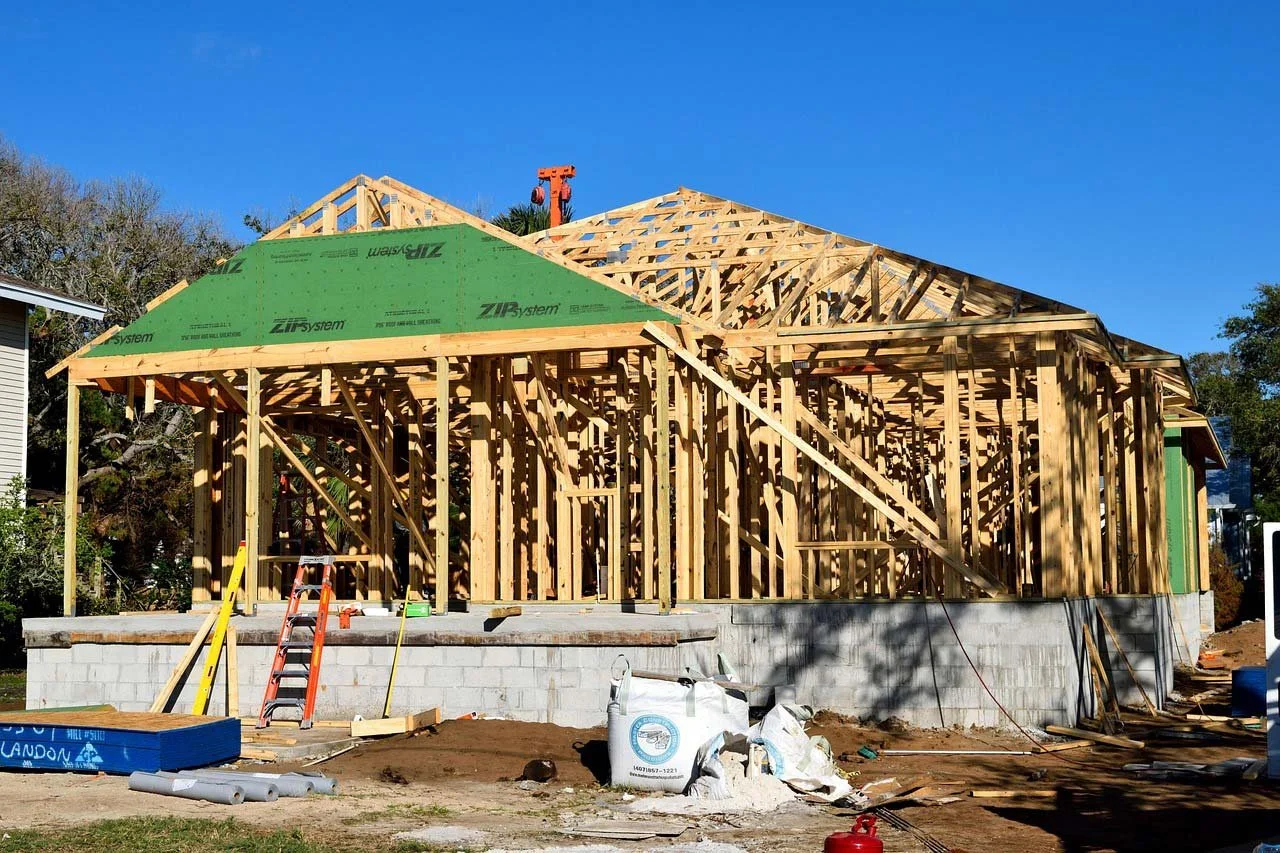 The wooden frame of a new home being built on a concrete block foundation.