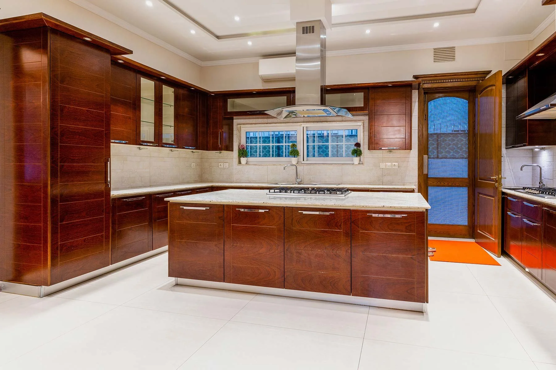 Modern kitchen with dark wood cabinets and marble countertops, emphasizing elegant interior design in Cornelius, NC.