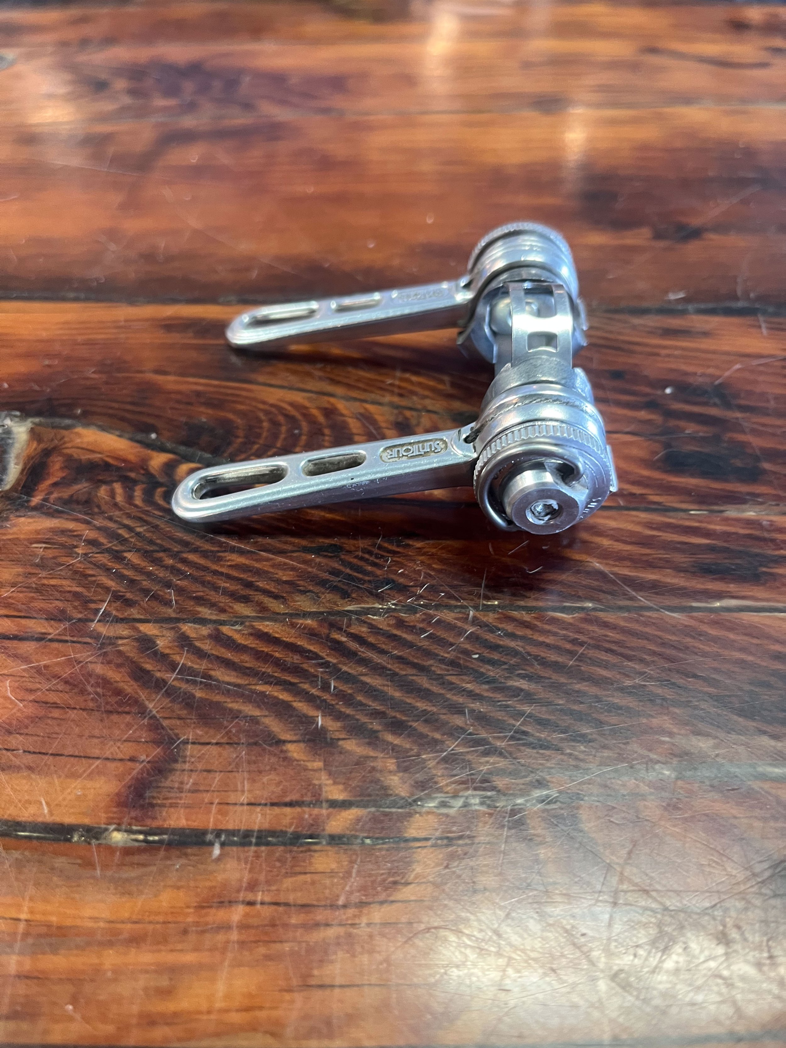 Photo of a pair of vintage Suntour downtube shifters with clamp for sale.