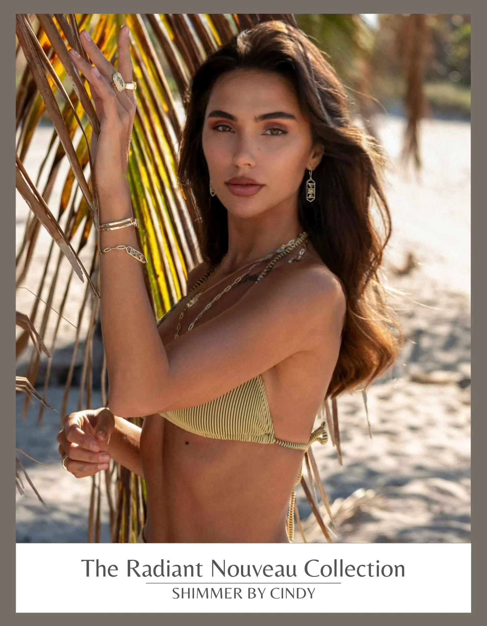 Woman with jewelry by a window, wearing earrings, bracelet, and rings, looking out at water view. "The Radiant Nouveau Collection - Shimmer by Cindy" text at the bottom.