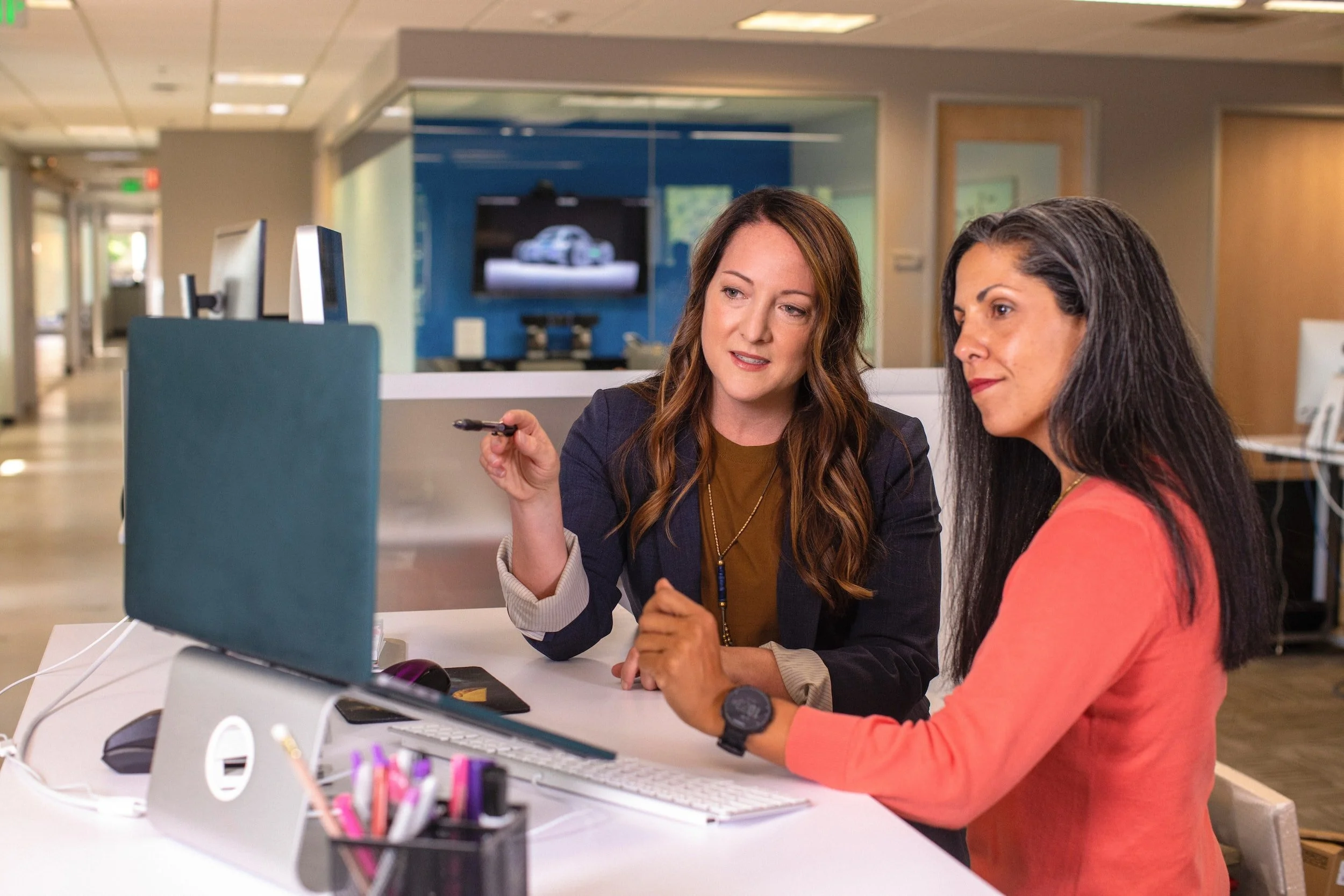 Two female property management professionals looking at a computer