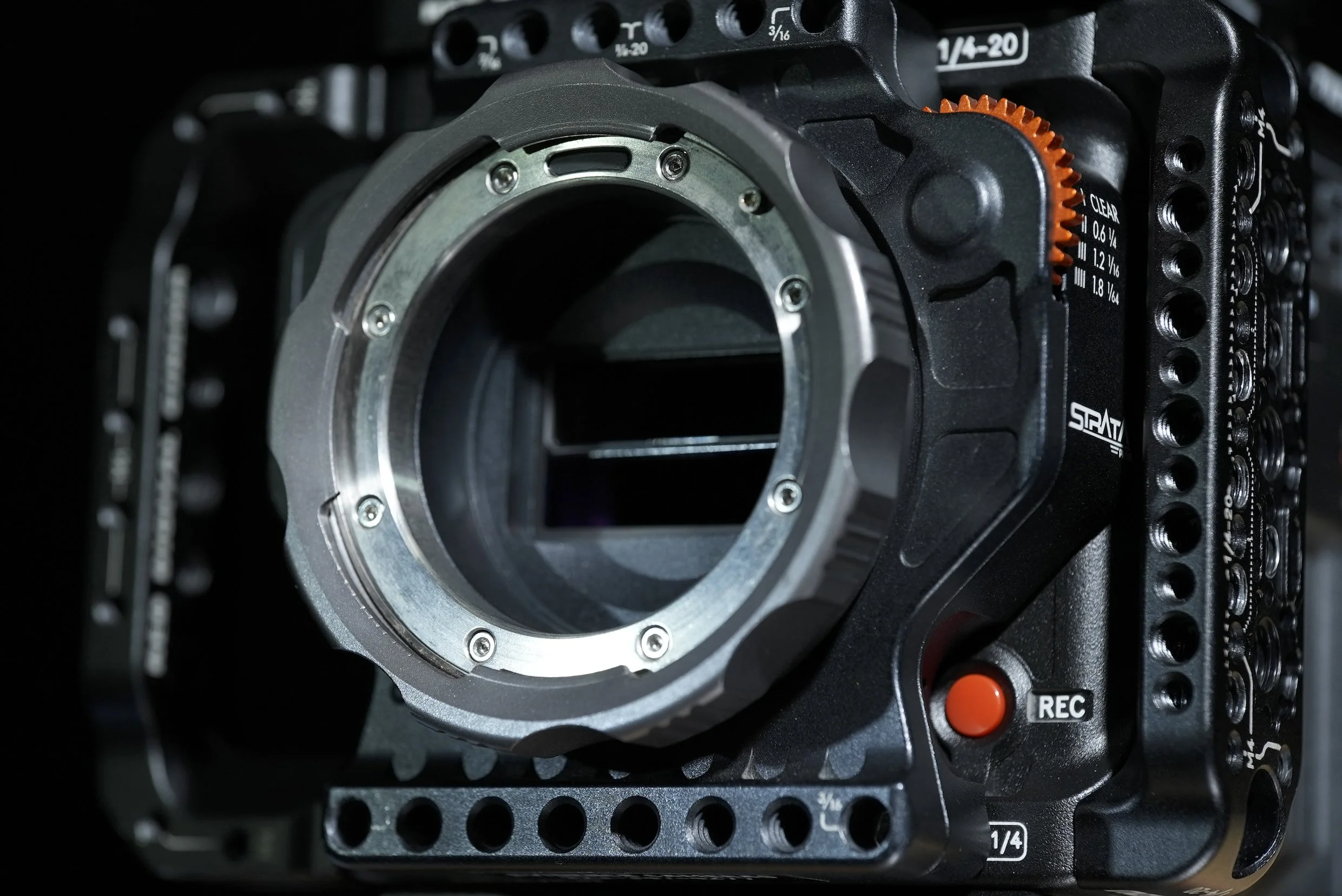 Close-up of a camera camera body with a lens mount, camera controls, and buttons visible.
