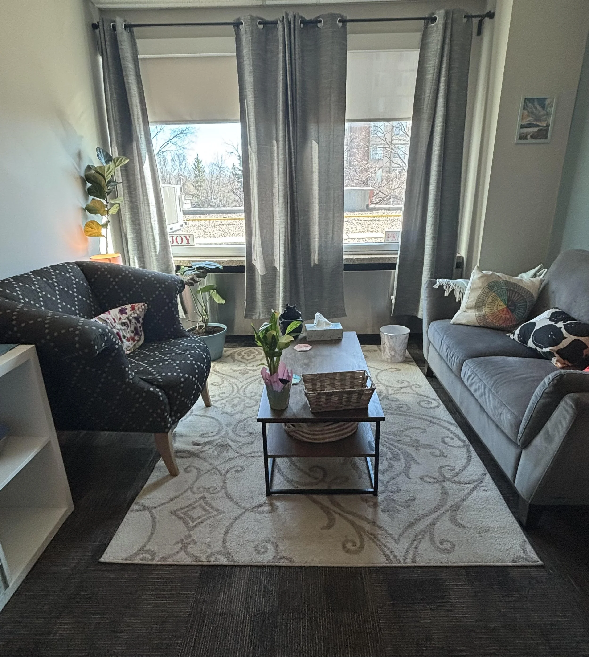 York Psychology Inc.'s therapy office, with accessible and comfortable couches and chairs, bright windows, and calm lighting.