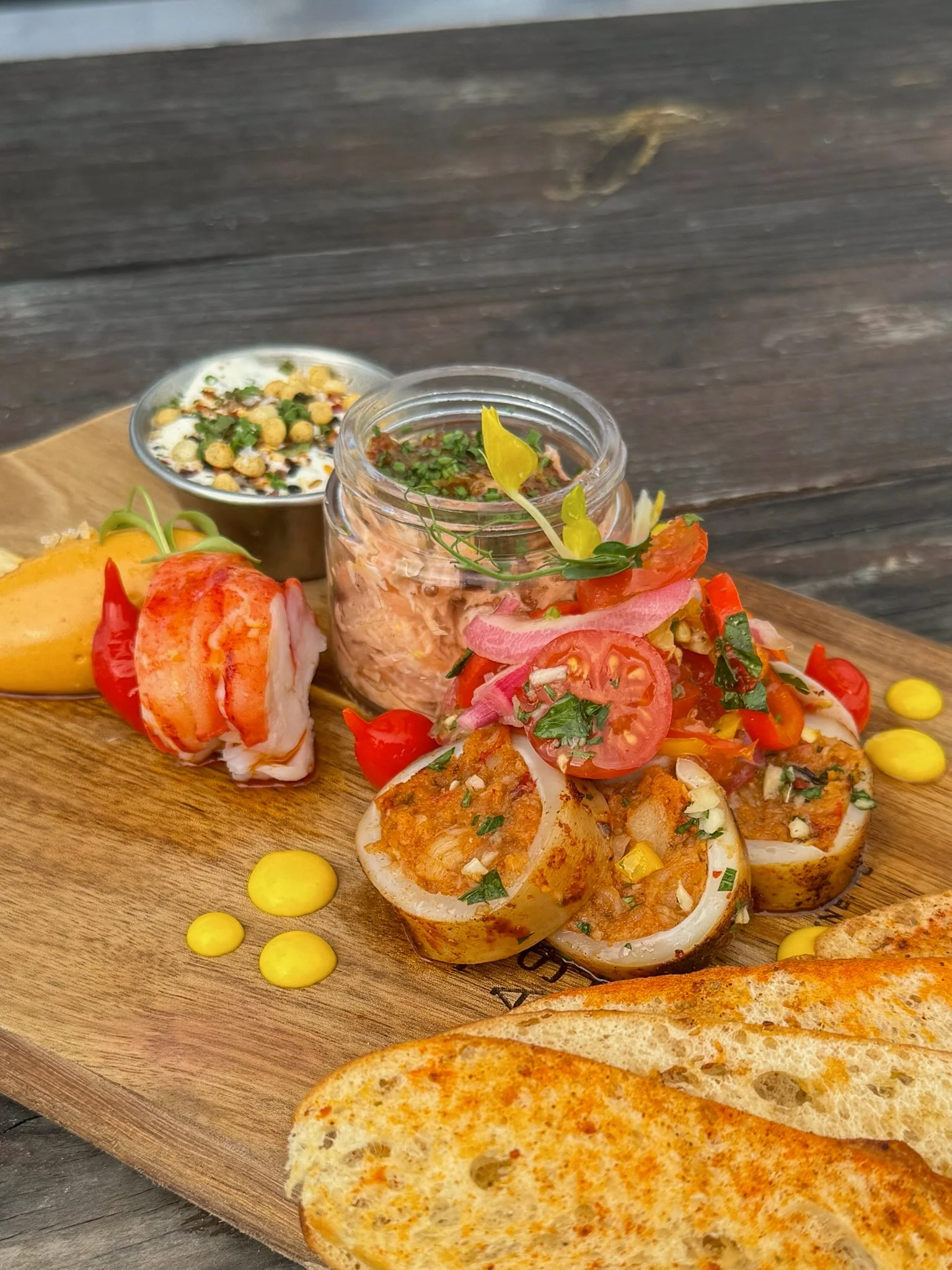 Seacuterie board featuring house-made seafood specialties, sauces, spreads, and crisp crostini, served at Asado Life.