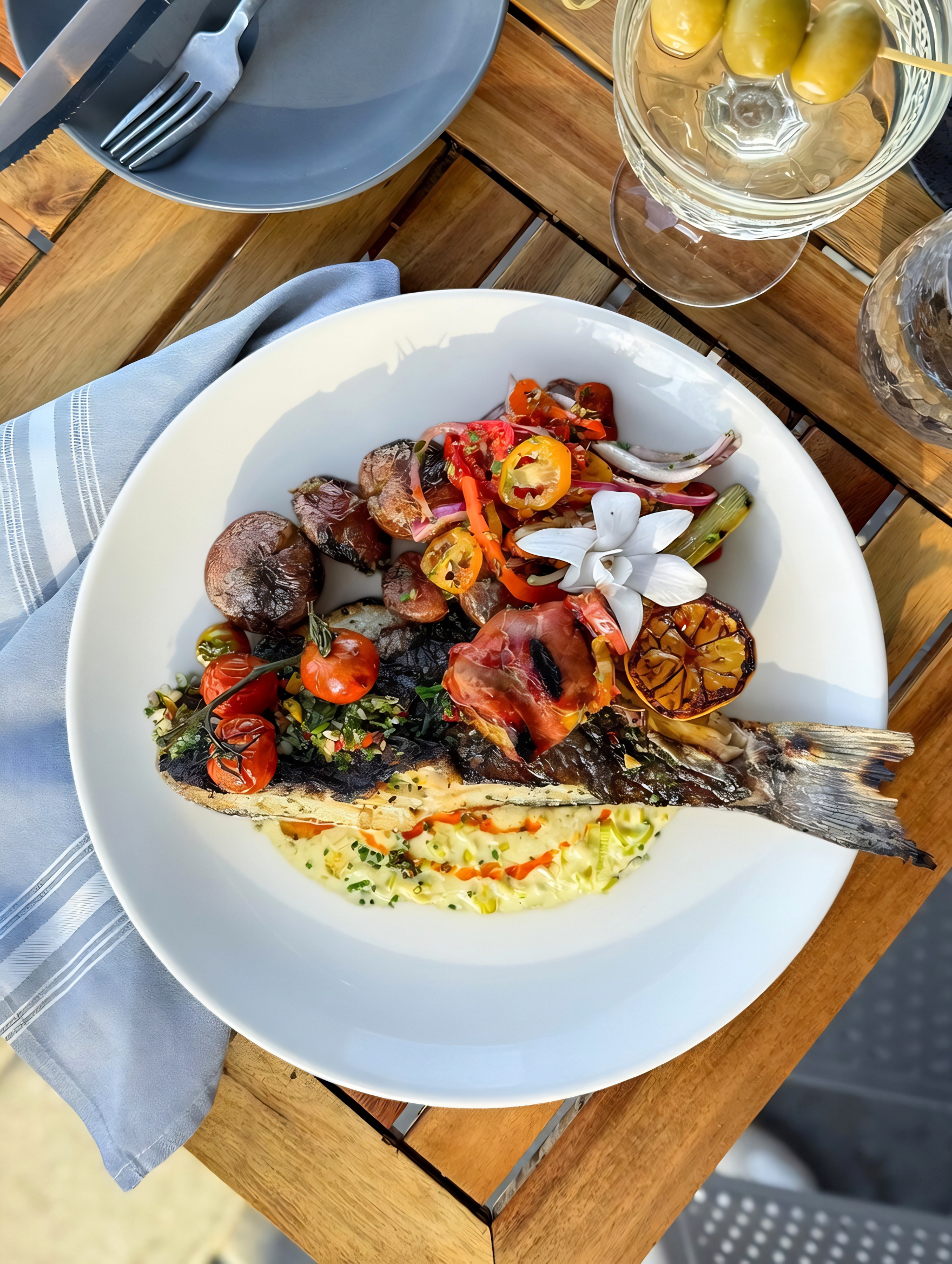Crispy skin-on Mediterranean sea bass filet served with melted leeks, prosciutto-wrapped artichokes, grilled red potatoes, charred lemon, and salsa criolla.