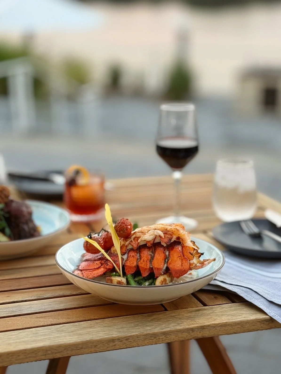 Lobster Gnocchi dish on a table with a glass of wine