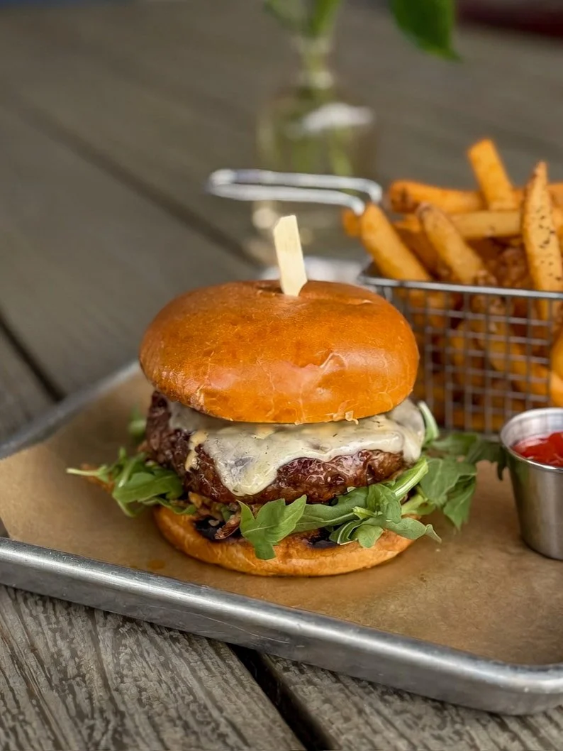 Americano Burger plated with a basket of fries