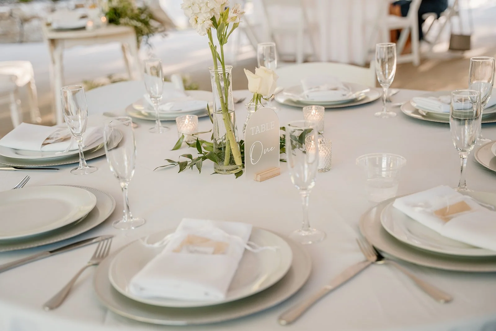wedding reception table with all white place settings