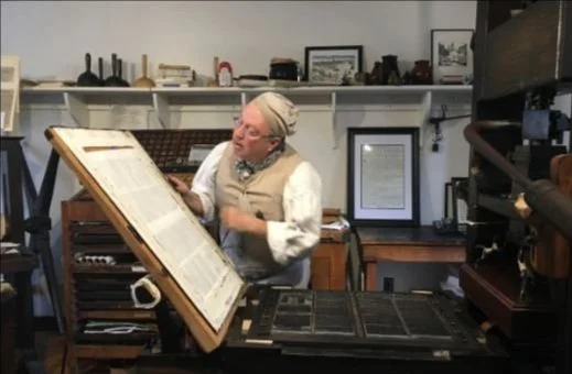 Colonial printing press demonstration at the Printing Office of Edes and Gill