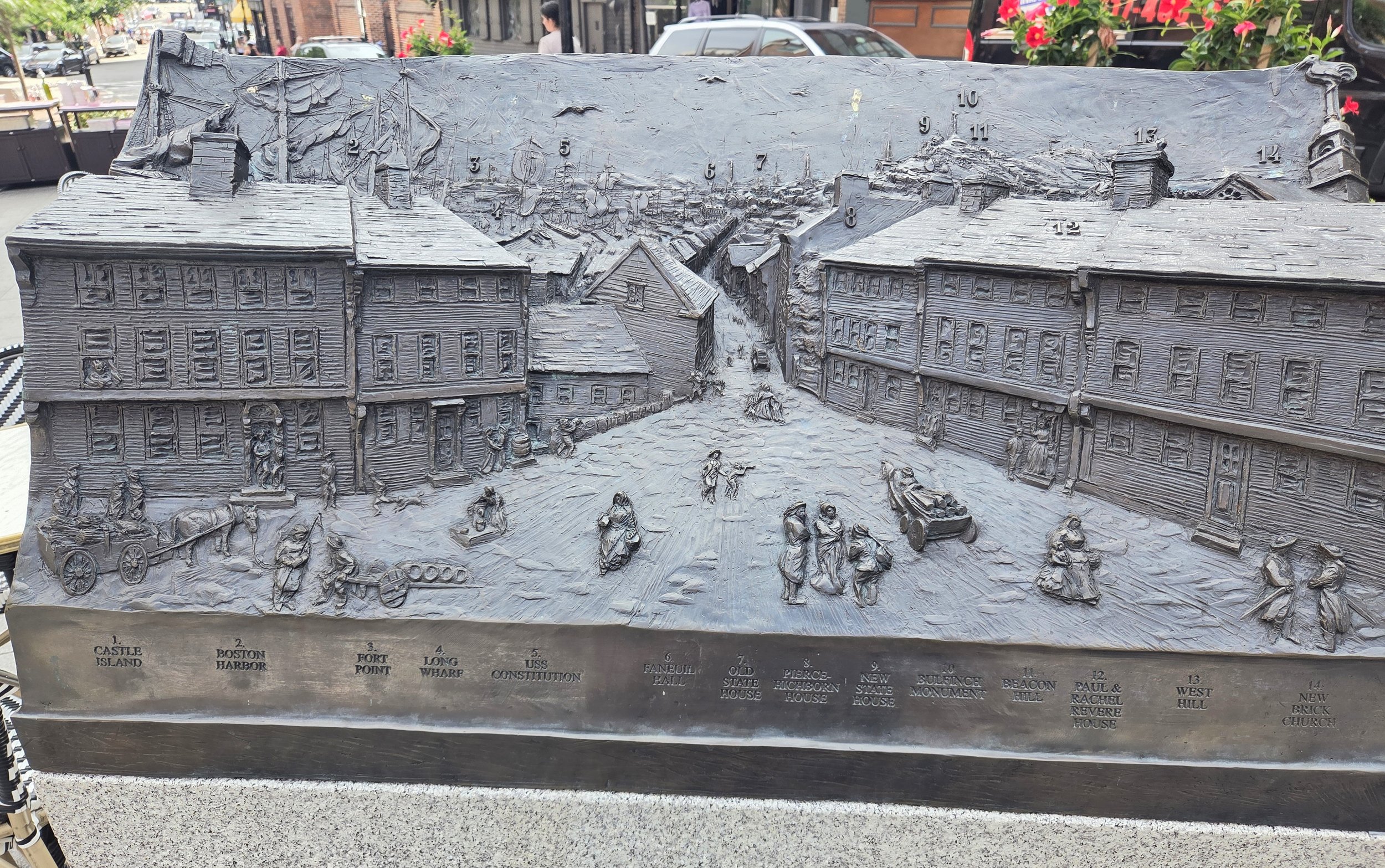 central dirt road with wooden houses along either side. historic representation of 1789 North Square