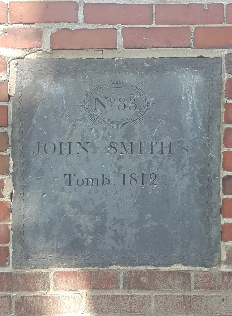 Pristine tomb plaque bearing the name John Smith in the lower burying ground