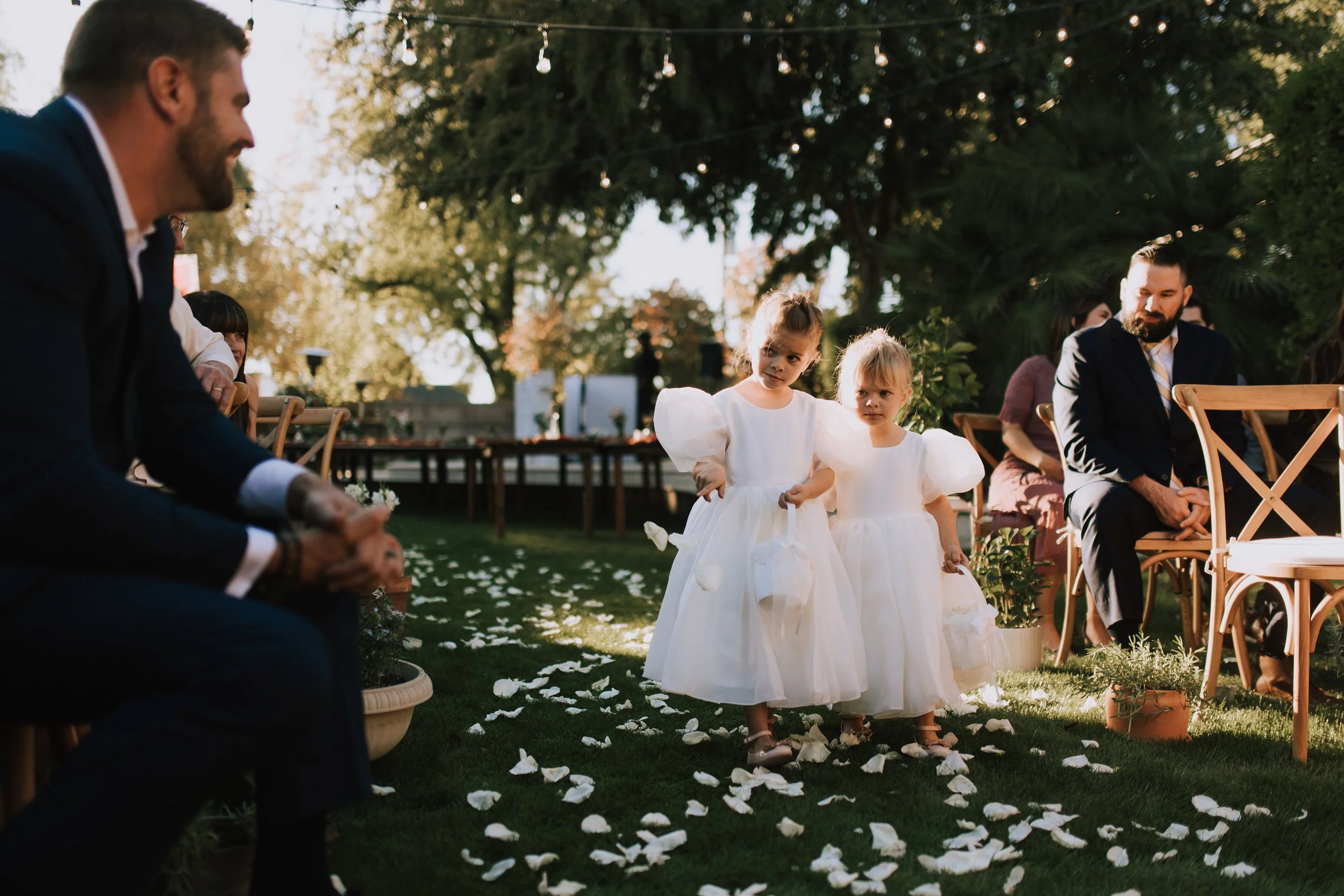 Flower girl smiles at wedding guest. Backyard wedding. Mesa, Arizona. Canon R5.