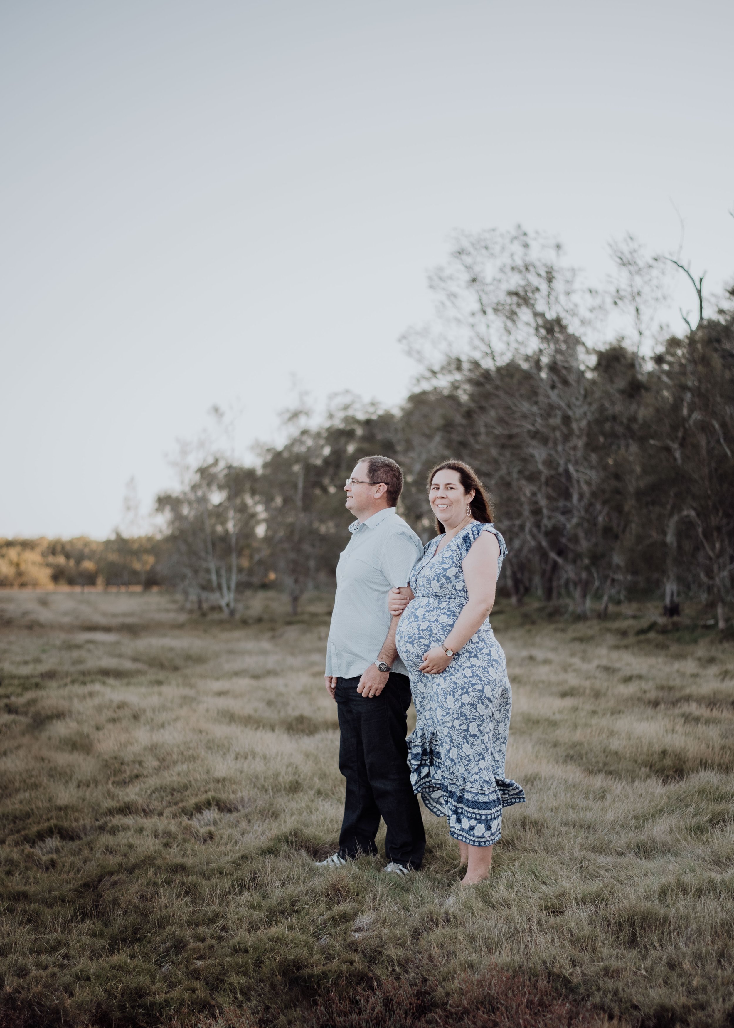  maternity photo shoot brisbane couple standing in field   