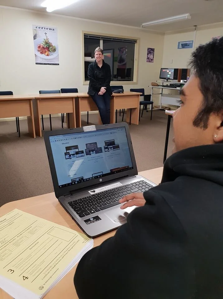 photo of Kati, owner of Hot Lizard Designs presenting to students about website design, with one student looking at portfolio on their laptop