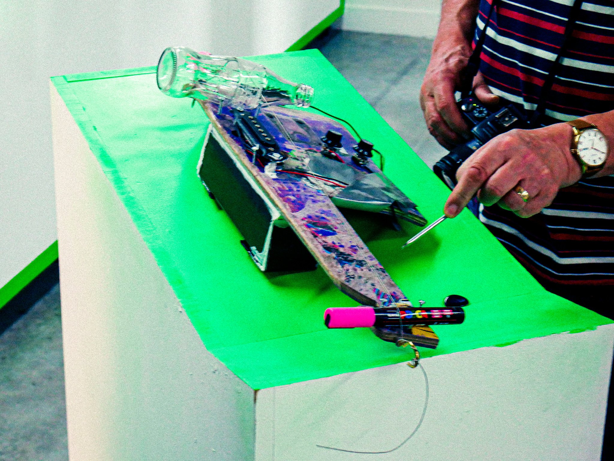 Electric diddley bow/slide guitar made from and old skateboard, guitar pickups and a glass bottle.