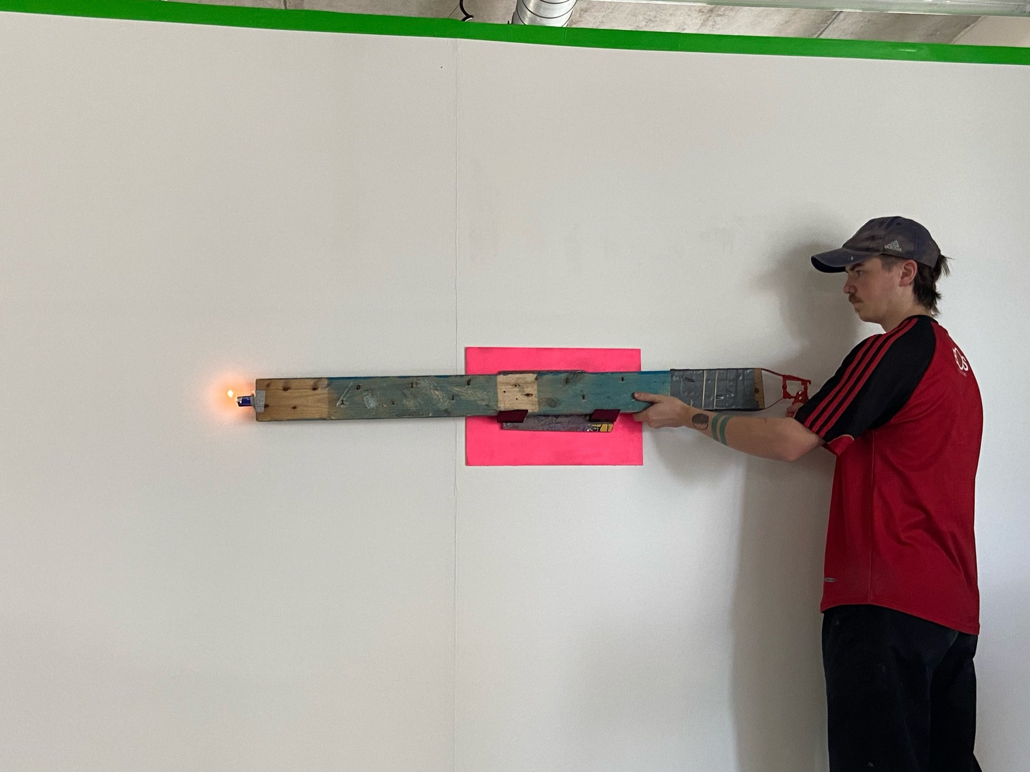 2 Metre long lighter made from wood, a caulk gun, a lighter and strimmer wire.