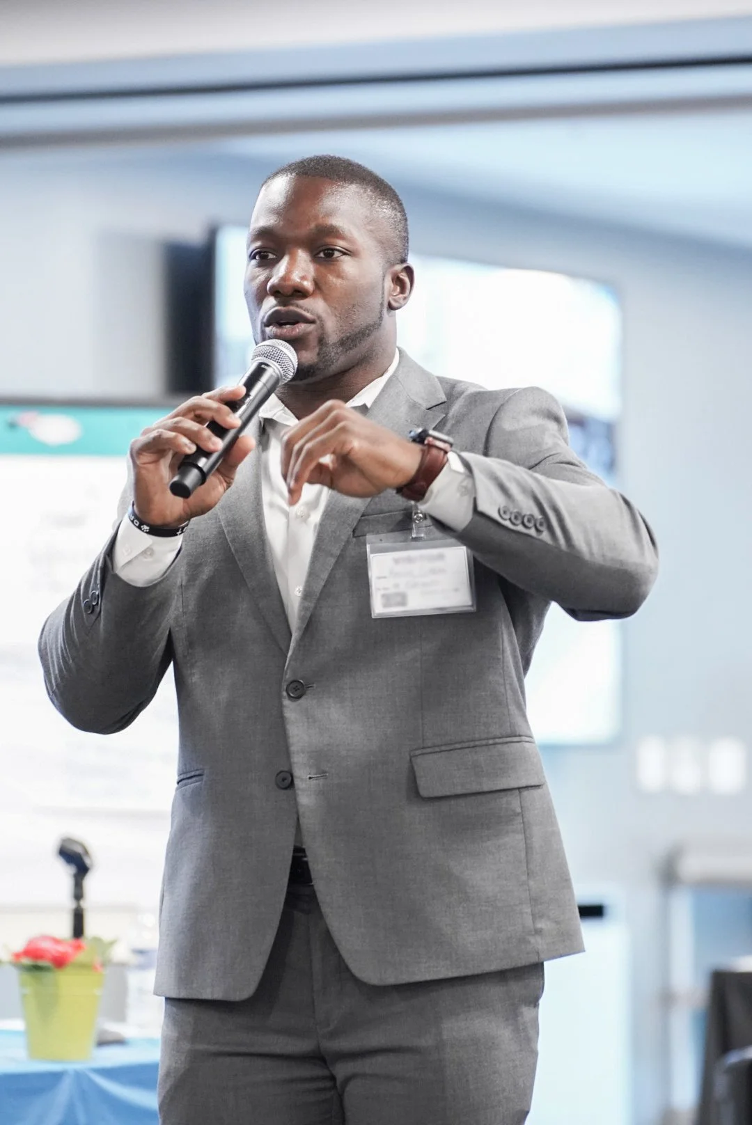 Man in gray suit speaking with microphone