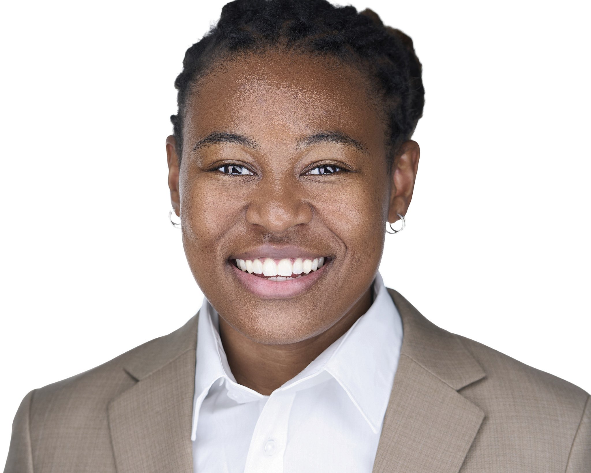 Close-up of a smiling woman with dark skin, short natural hair, wearing a gray blazer and white shirt, against a white background.