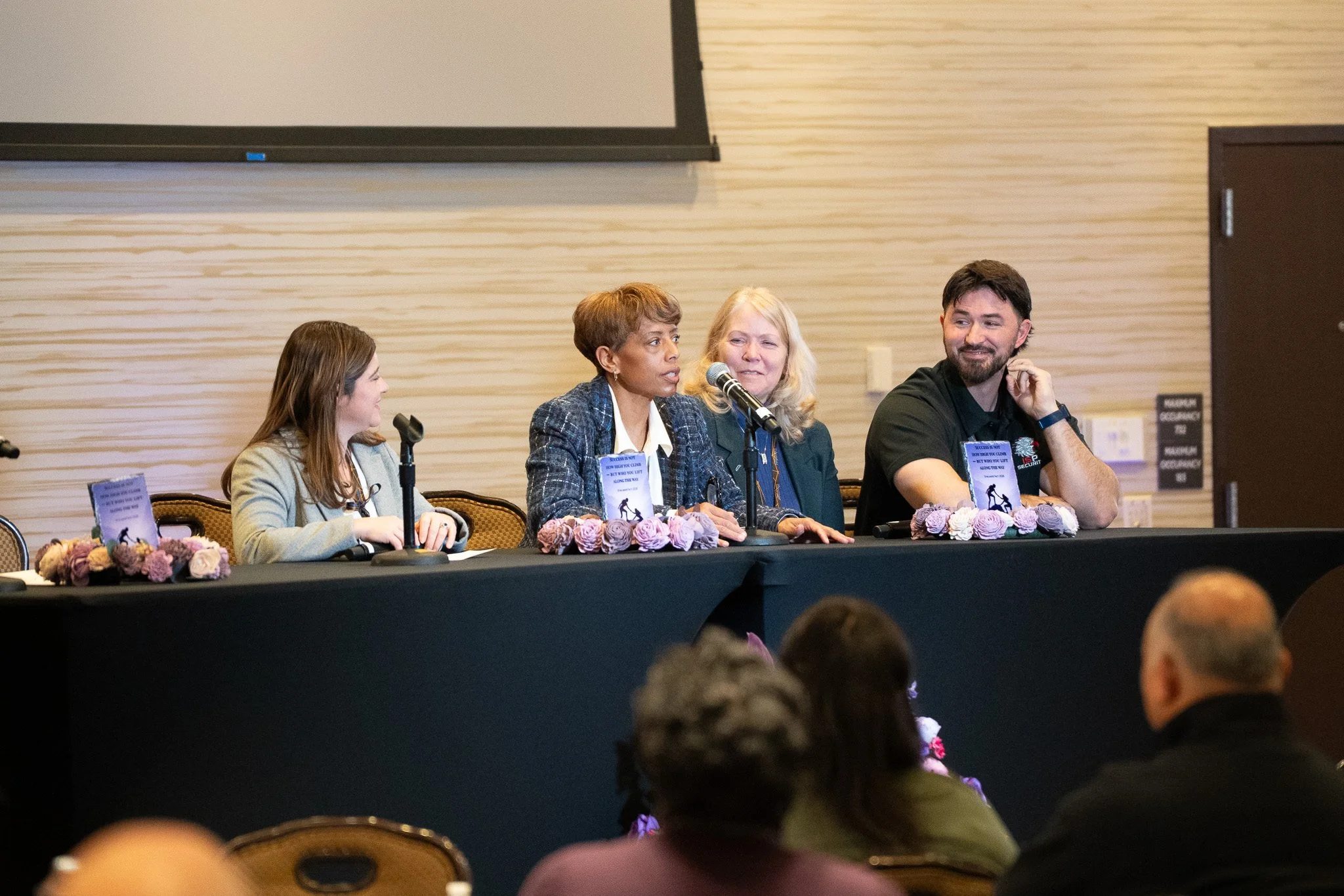 Panel of three women and one man at a table