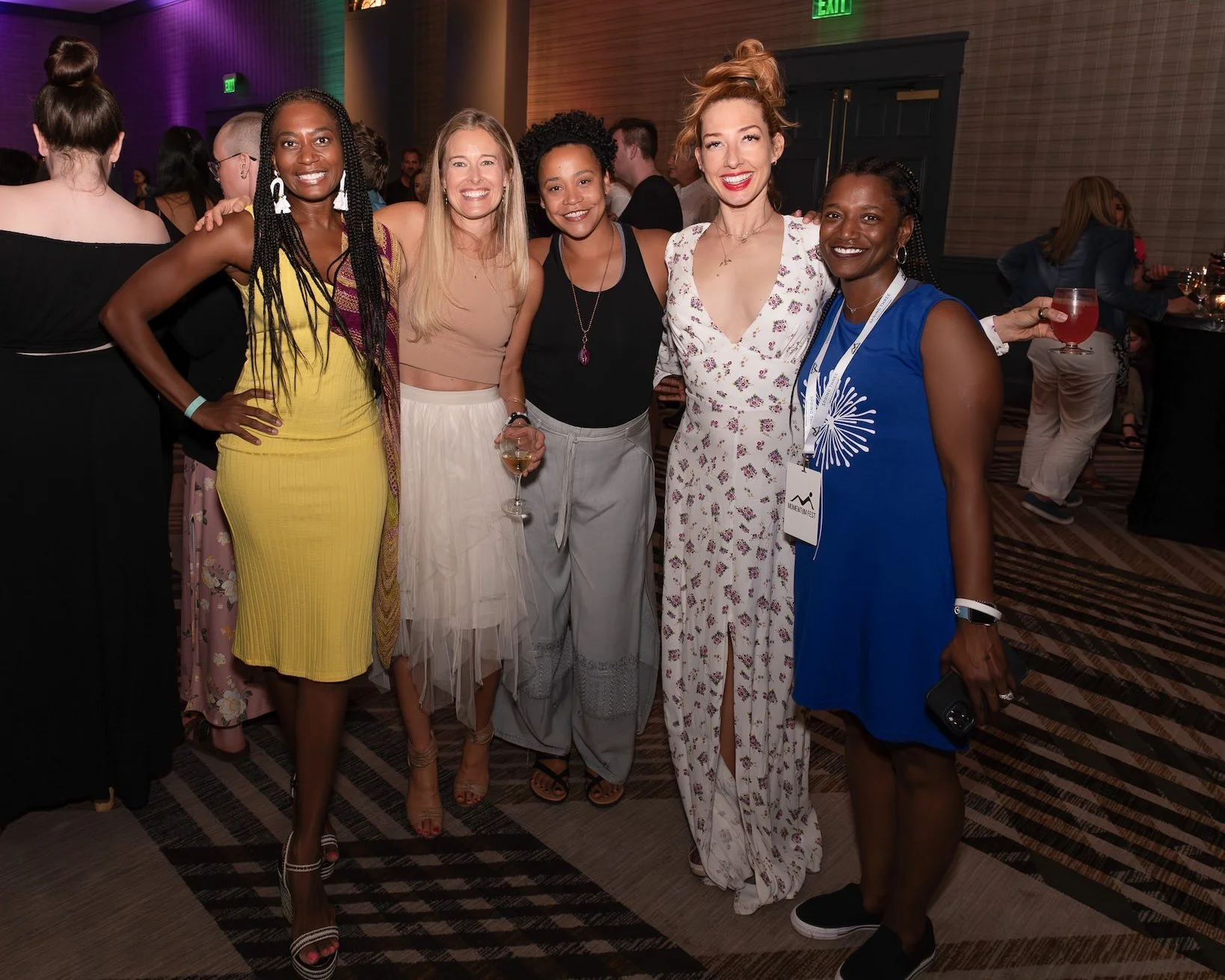 Five ladies at a conference event smiling.