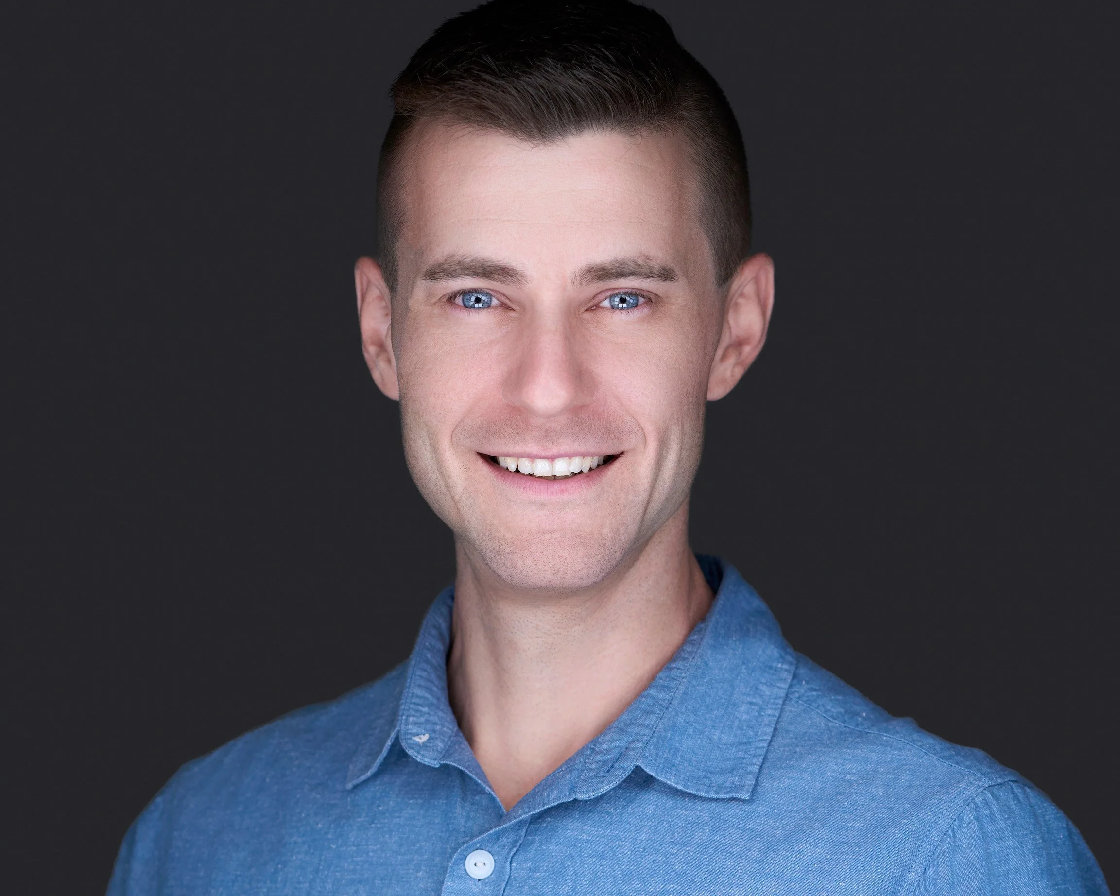 Professional headshot of man in blue shirt in Brighton CO.