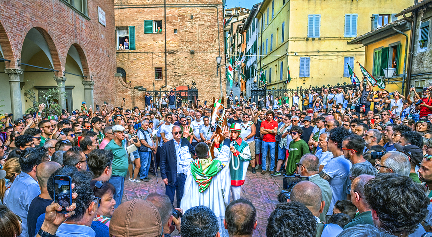 Priest blessing the horse representing the Oca Contrada for the Palio di Provenzano horse race - Siena, Italy - July 2024