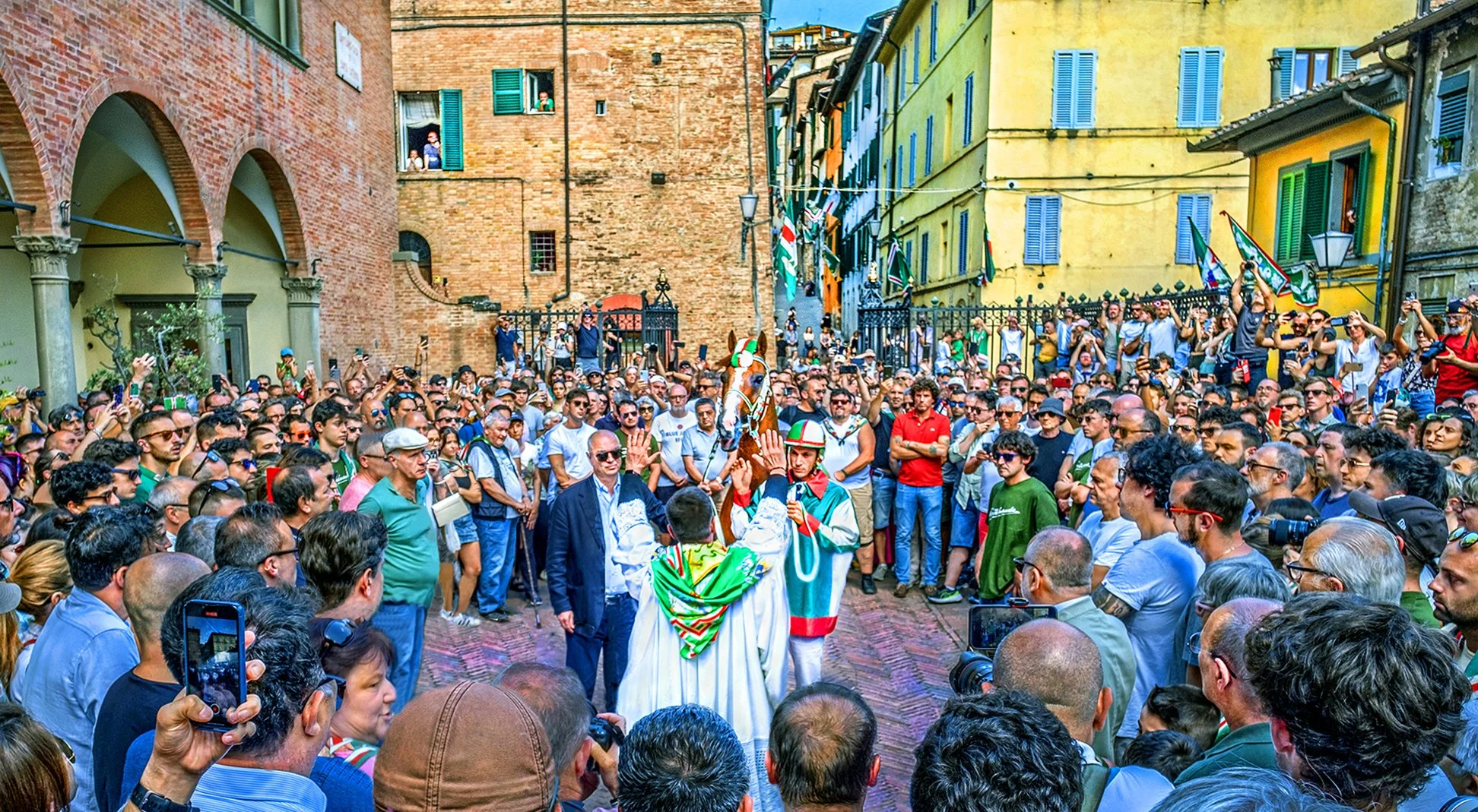 Priest blessing the horse representing the Oca Contrada for the Palio di Provenzano horse race - Siena, Italy - July 2024