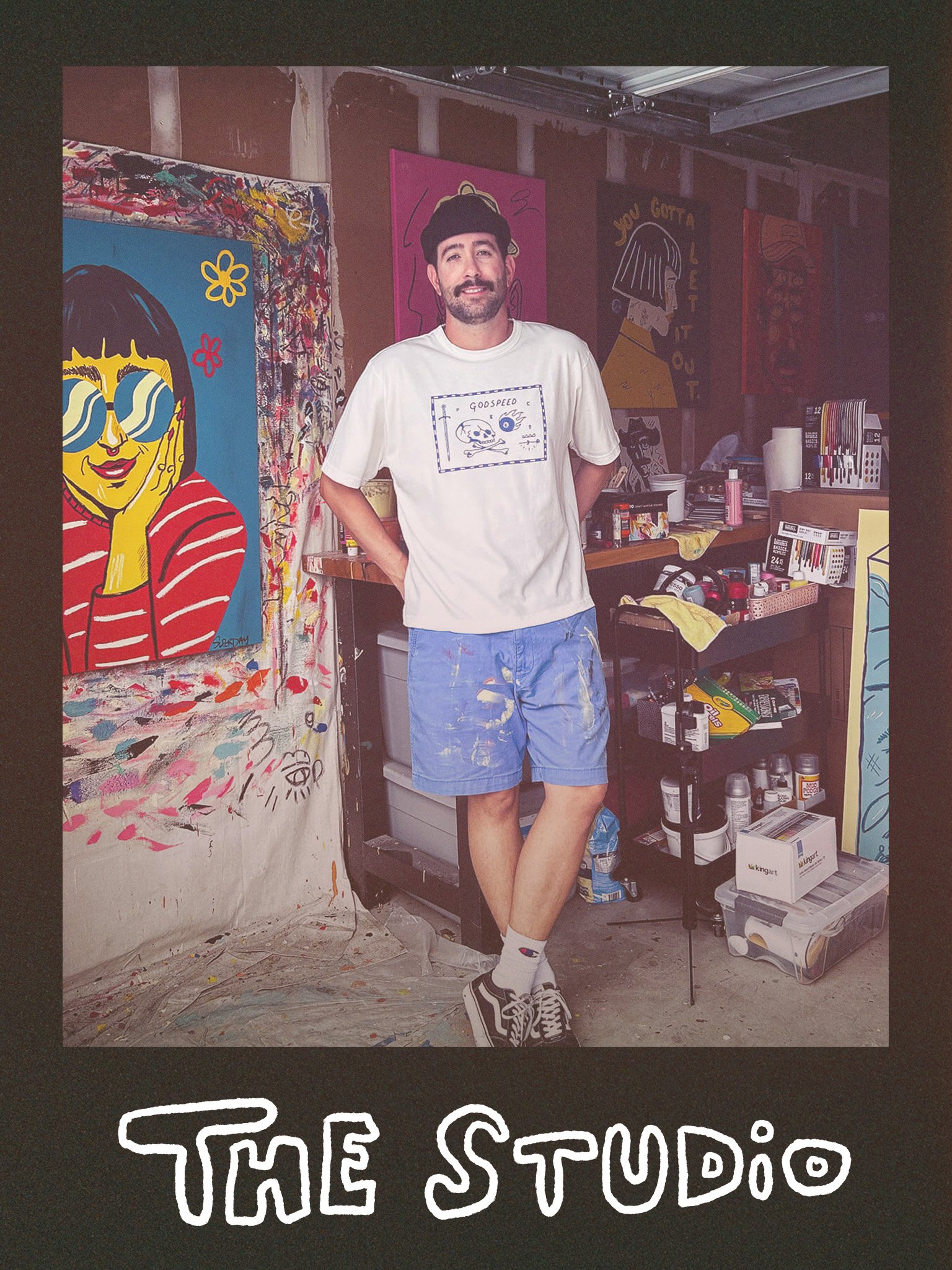 Diego standing in his studio wearing a white shirt and blue shorts. The words "The studio" are written underneath the photo.