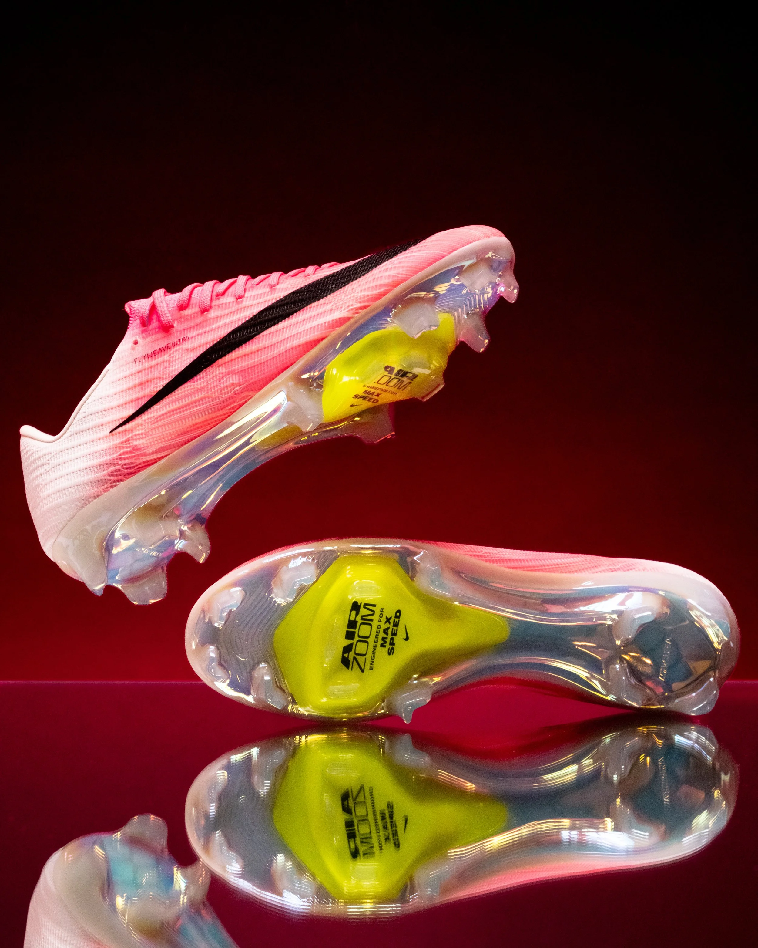 Pink and black Nike Alpha Menace 3 football cleat with a yellow Nike Zoom Air Max sole, set against a dark red background.