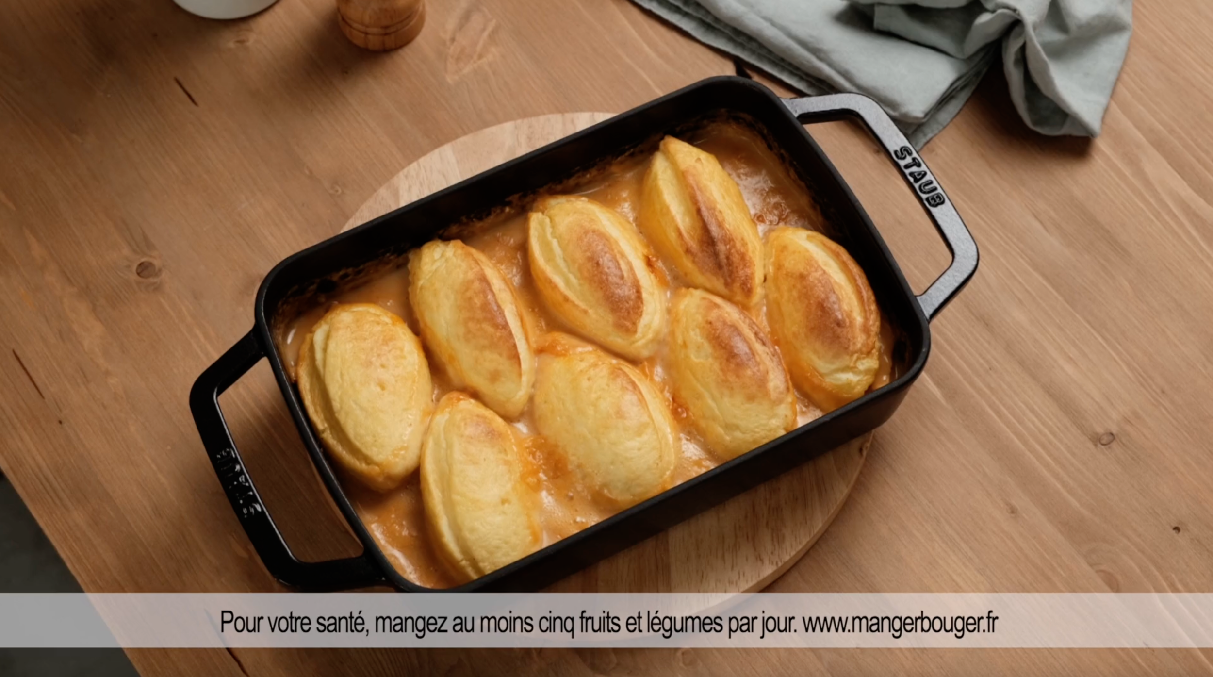 Gâteau aux fruits dans un plat en métal noir sur une table en bois.