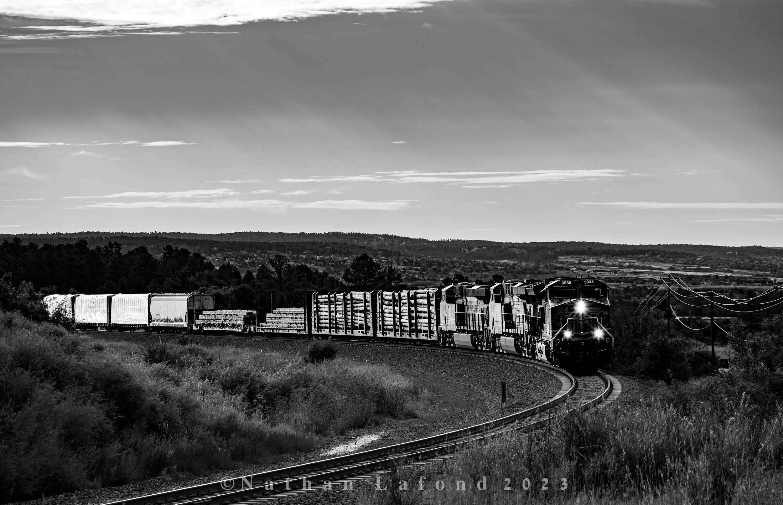 A train of miscellaneous freight grinds its way up the hill at Palmer Lake on a warm August morning. - Palmer Lake, Colorado.