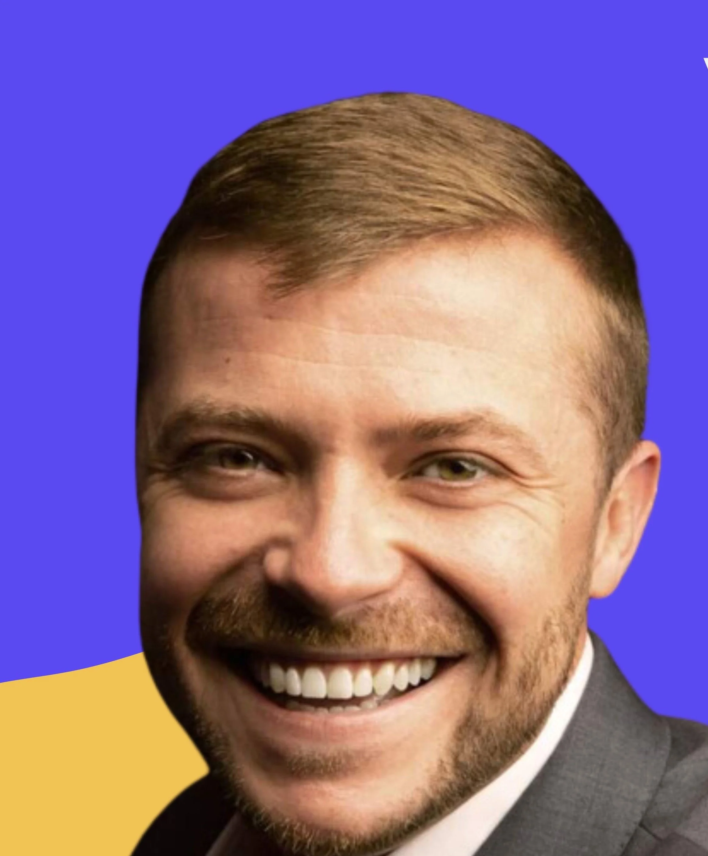 Close-up of a smiling man with short brown hair, light skin, and a beard, wearing a suit jacket, against a colorful background with blue and yellow sections.