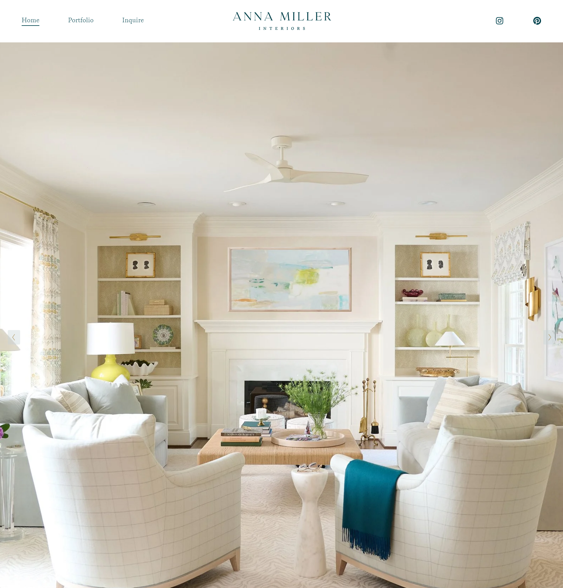 Living room with white plaid armchairs, a coffee table with books and plants, a fireplace with a large abstract painting above it, and lamps, decor, and curtains in light colors.