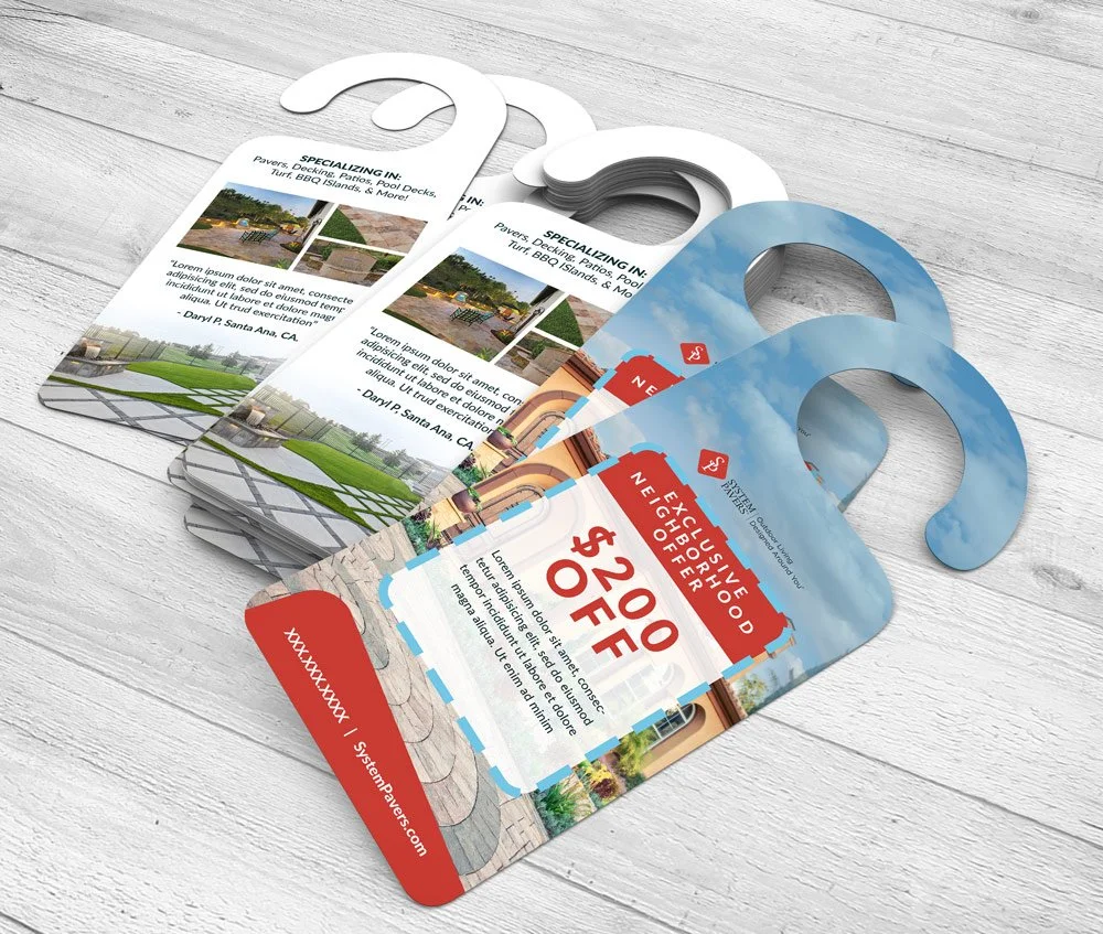 Three promotional door hangers on a wooden surface, advertising landscaping services and a special offer of $20 off.