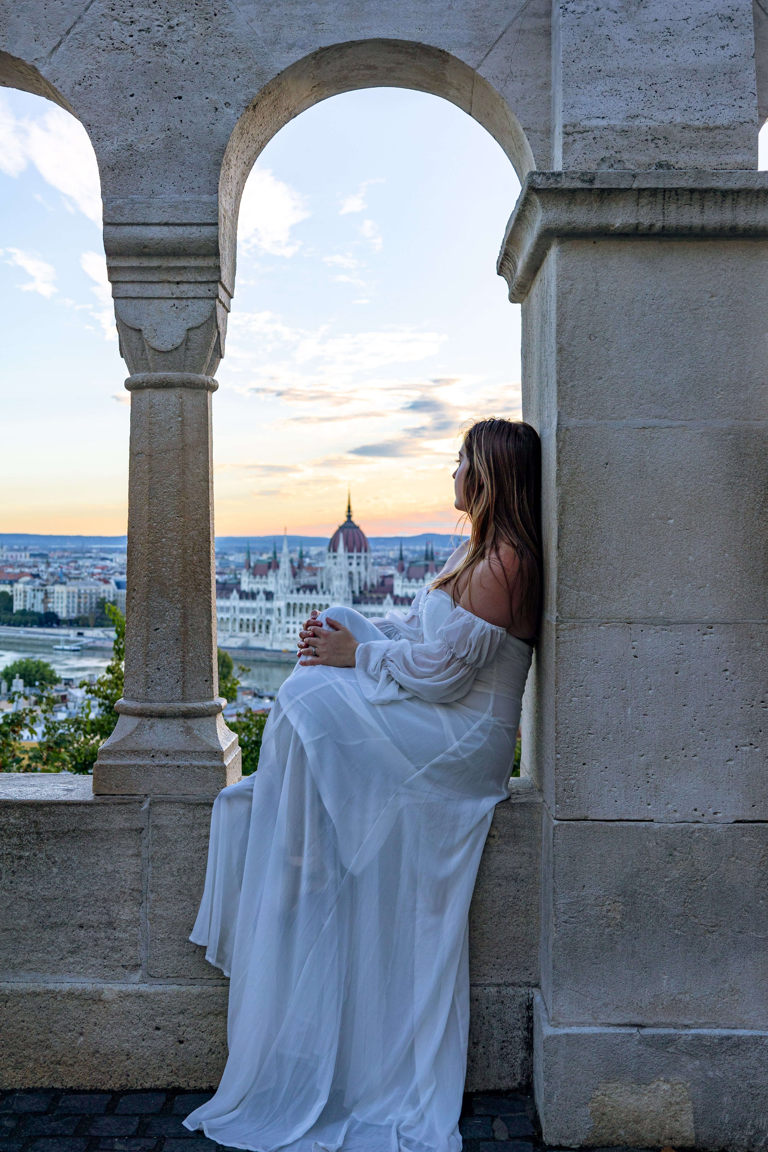 woman in window overlooking danube and parliament budapest hungary.jpg
