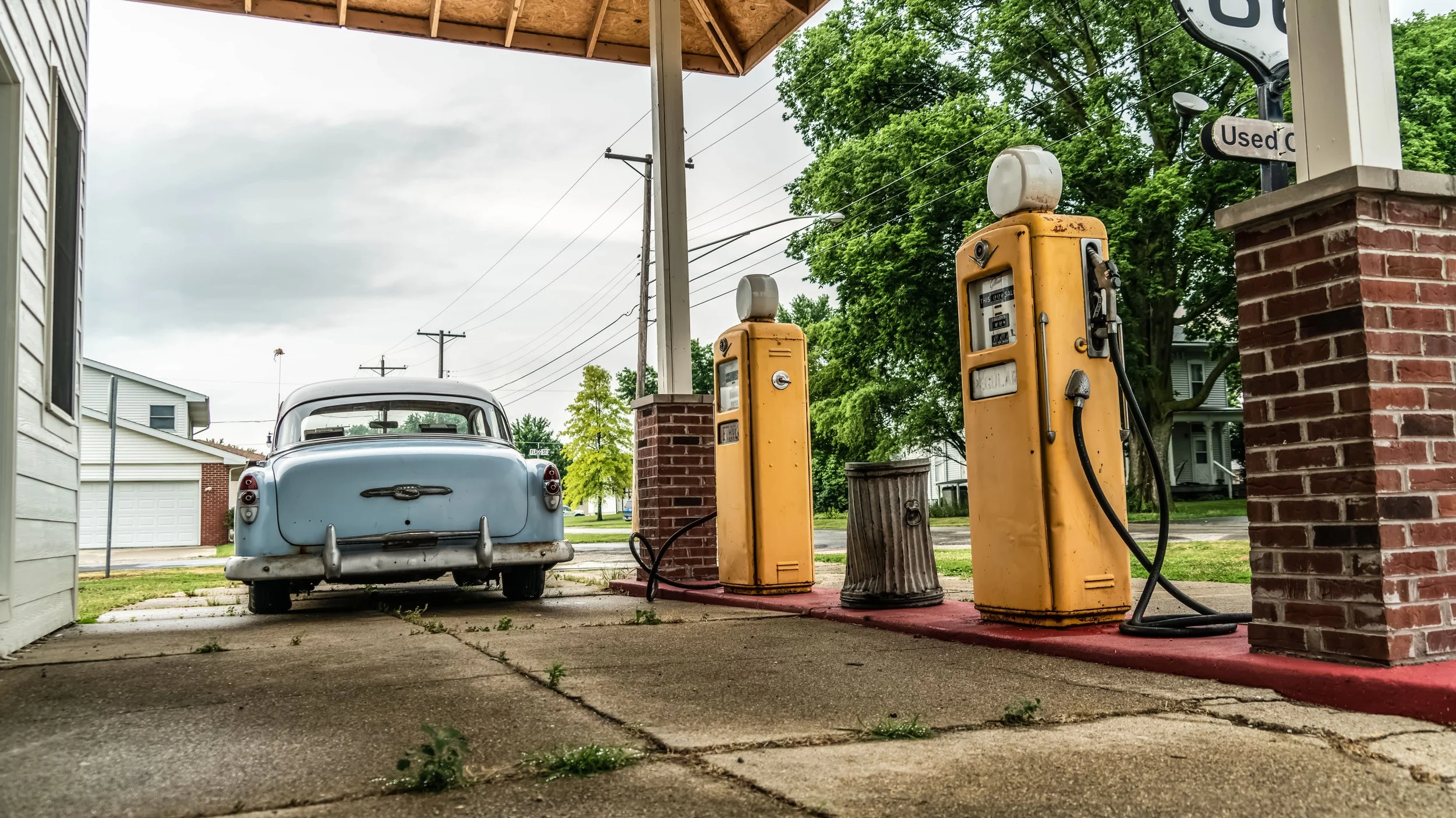Limited edition fine art photograph by Jason Sponseller, featuring a vintage car and yellow gas pumps at an old Route 66 service station in Williamsville, Illinois, with nostalgic Americana atmosphere