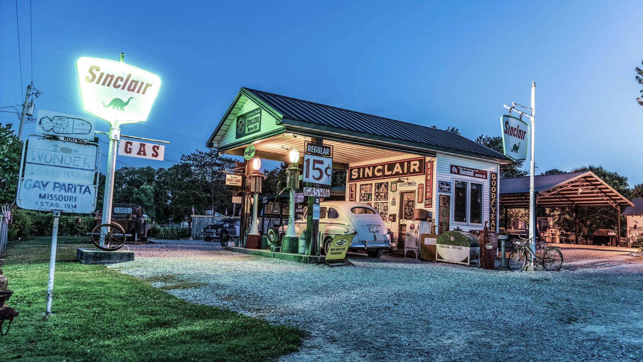 Limited edition fine art photograph by Jason Sponseller, featuring a vintage Sinclair gas station on Route 66 in Gay Parita, Missouri, with glowing neon signs, classic cars, and nostalgic Americana atmosphere