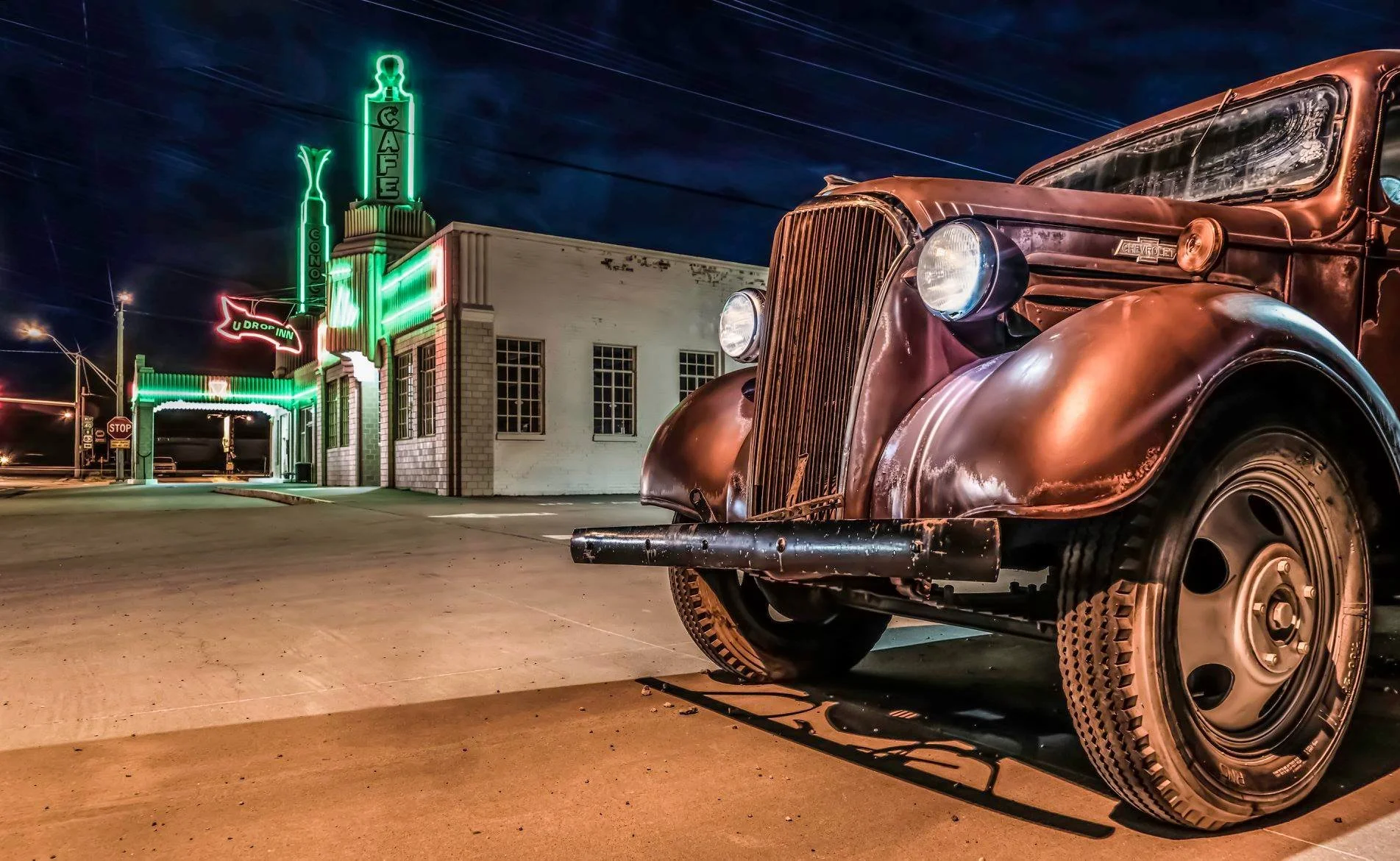 Limited edition fine art photograph by Jason Sponseller, featuring a vintage Chevrolet truck beside the neon-lit U-Drop Inn on Route 66, with classic Americana, night sky, and nostalgic roadside atmosphere