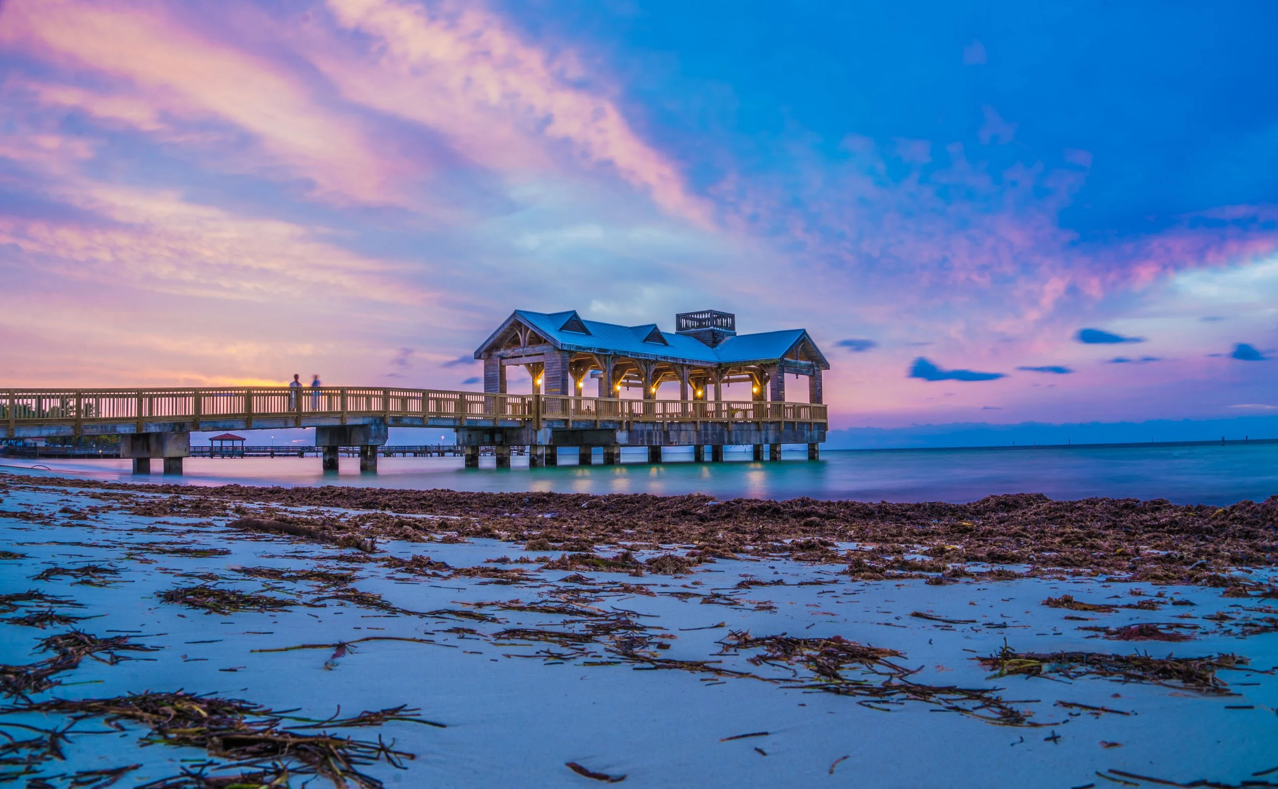 Coastal Vibes limited edition fine art photograph by Jason Sponseller, featuring The Reach Gazebo and Pier at The Reach Key West, Curio Collection by Hilton, at sunrise with pastel clouds, calm blue water, and relaxed coastal atmosphere